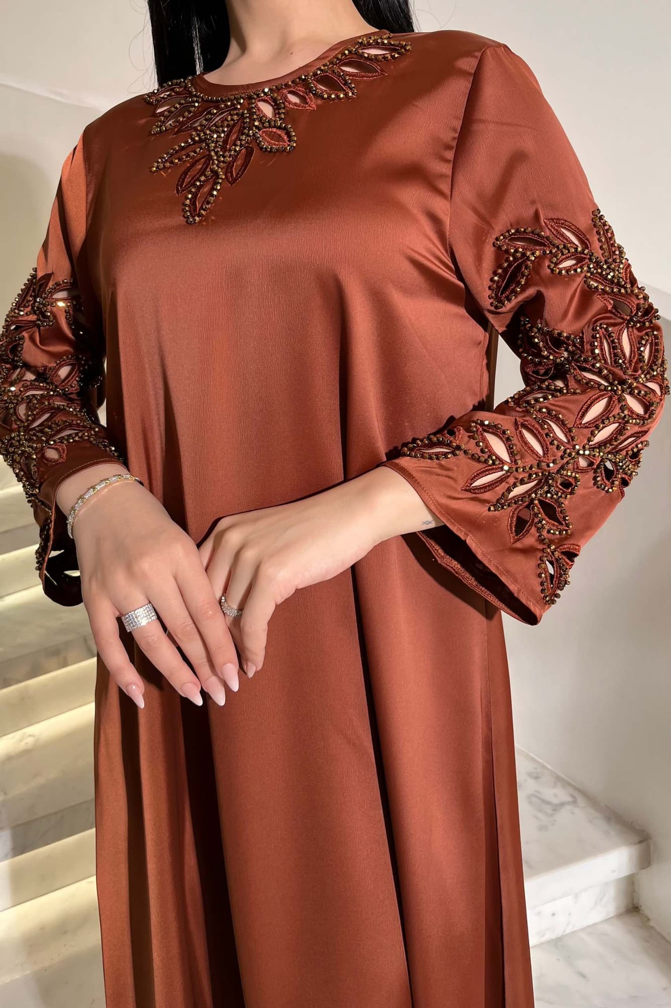 جلابية أنيقة بتصميم واسع بقصّة انسيابية مع تطريز ناعم وبارز طوبي