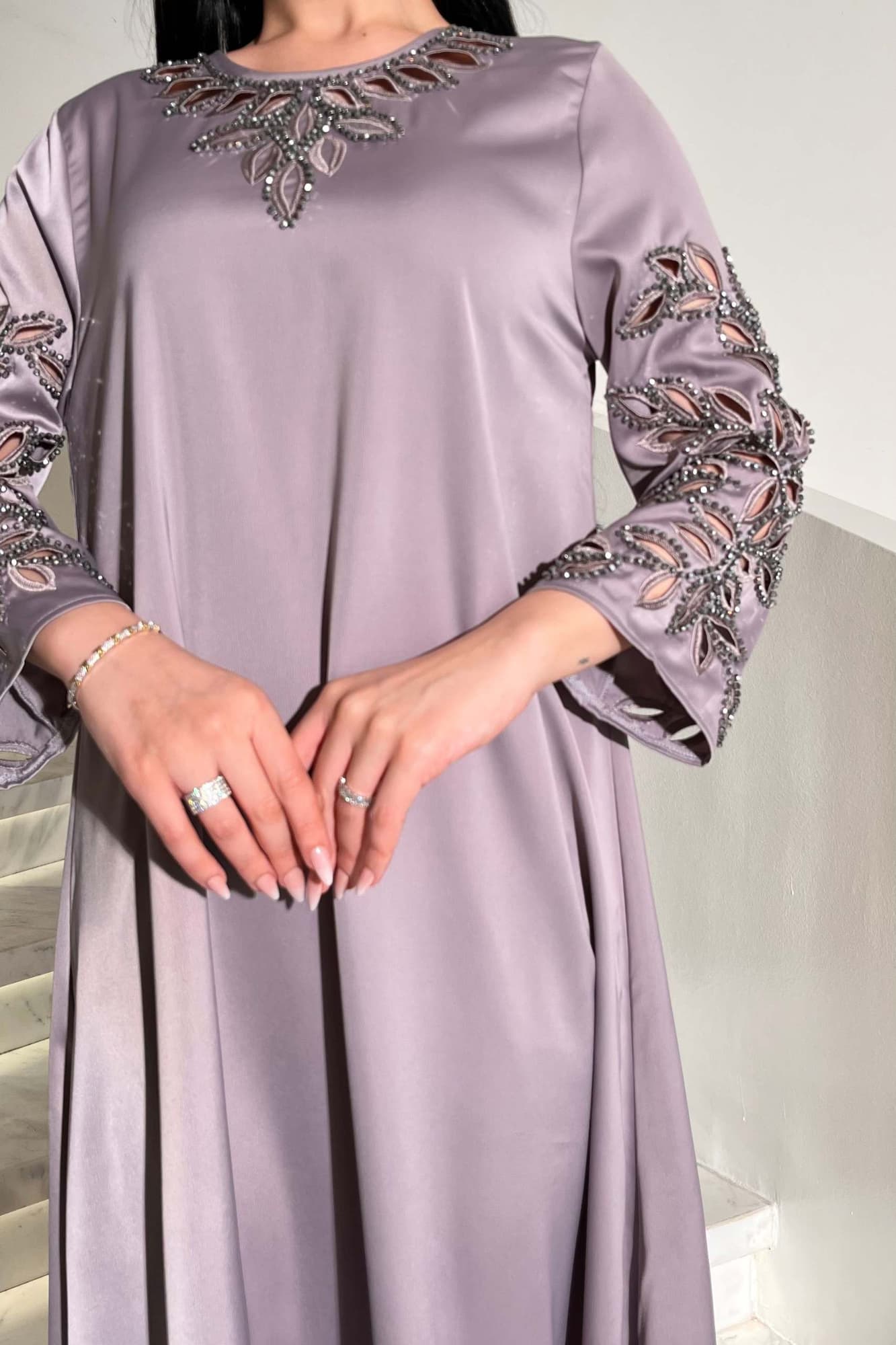 جلابية أنيقة بتصميم واسع بقصّة انسيابية مع تطريز ناعم وبارز رصاصي فاتح