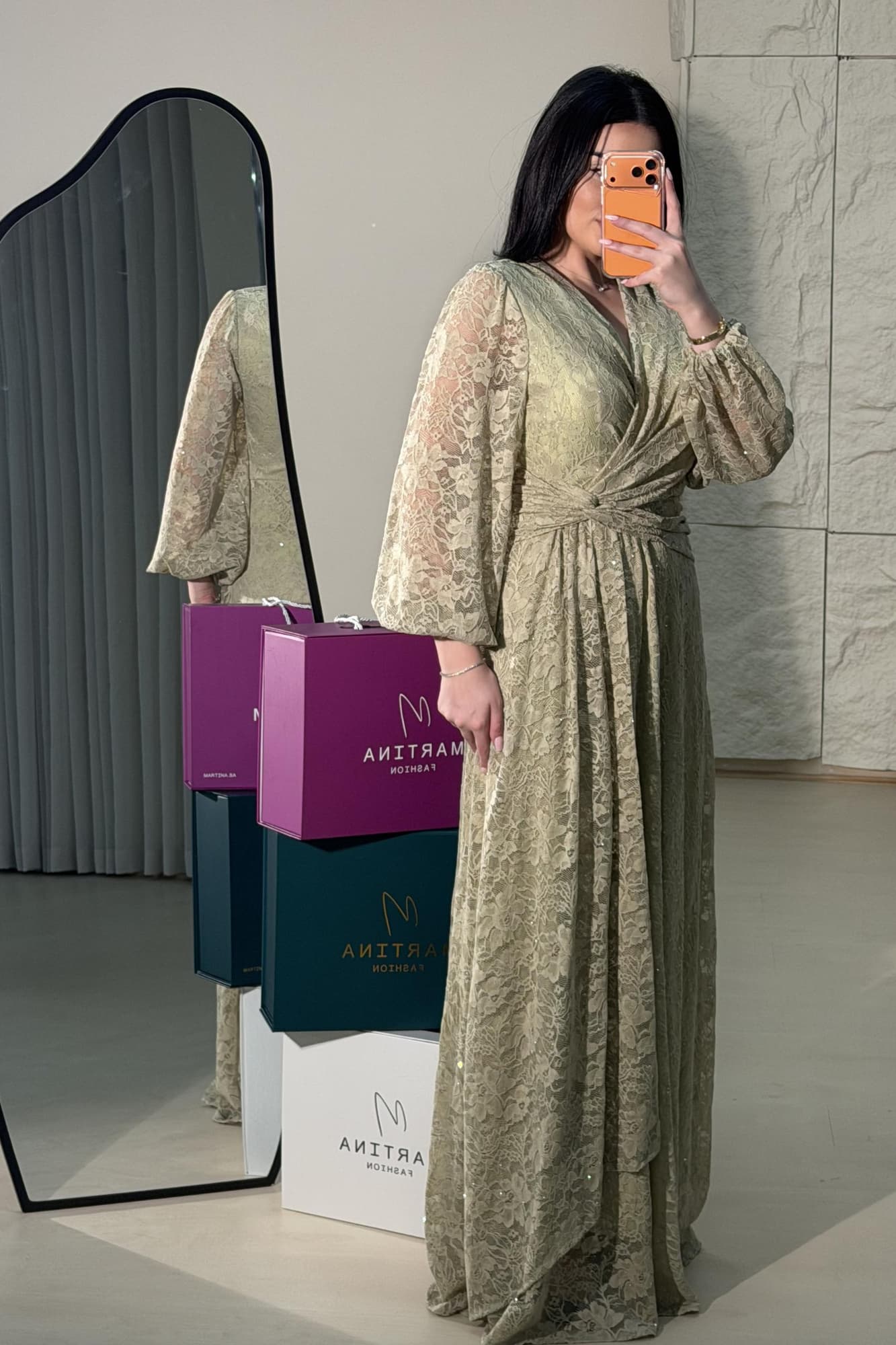 فستان طويل من الدانتيل بلون أخضر فاتح هادئ، يعكس أنوثة راقية ولمسة رومانسية ناعمة يتميّز بقصّة لفّ (Wrap) أنيقة مع عقدة جانبية تبرز الخصر