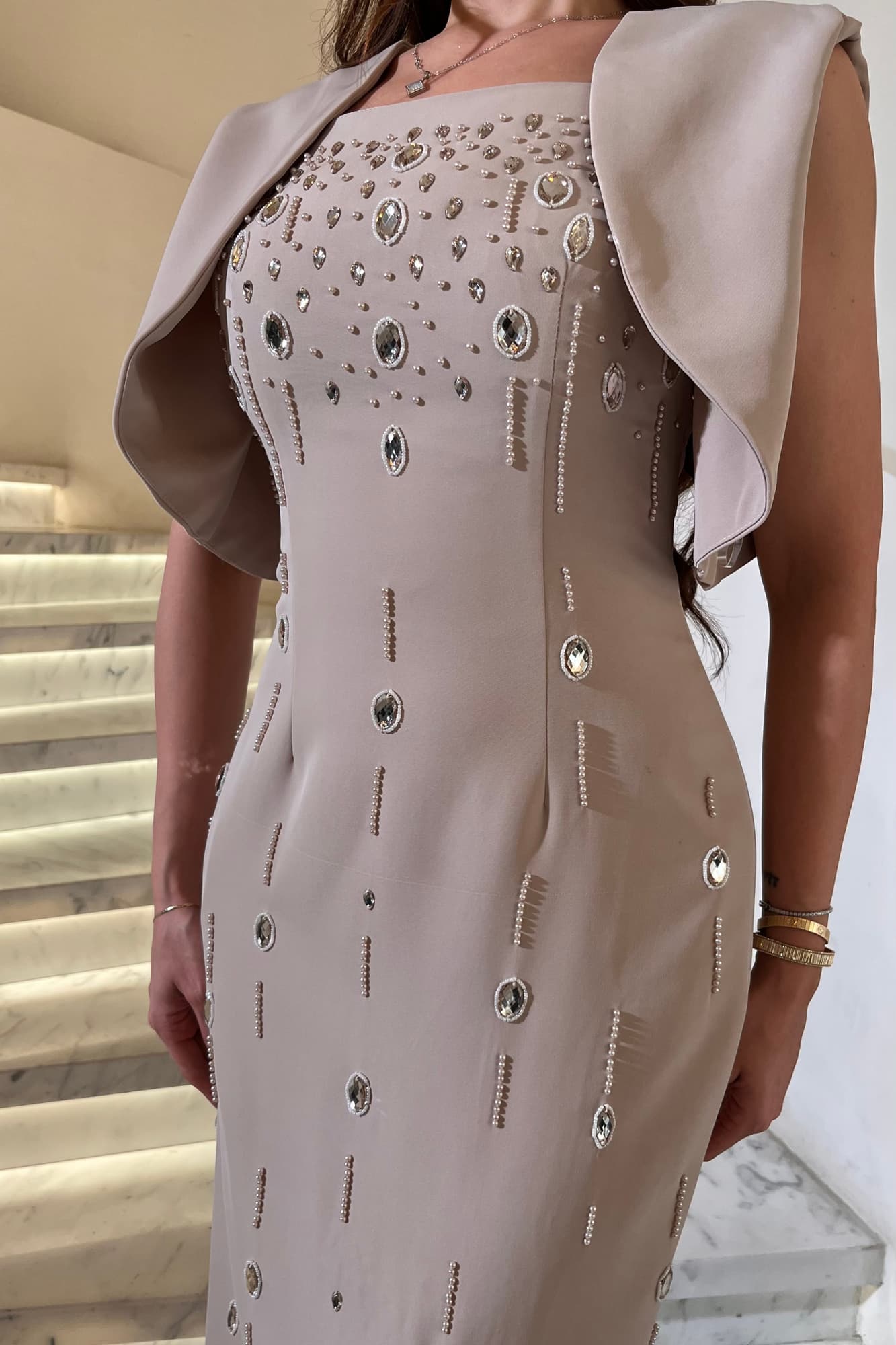 فستان سهرة طويل بتصميم أنيق ينساب على القوام ويبرز أنوثته بيج