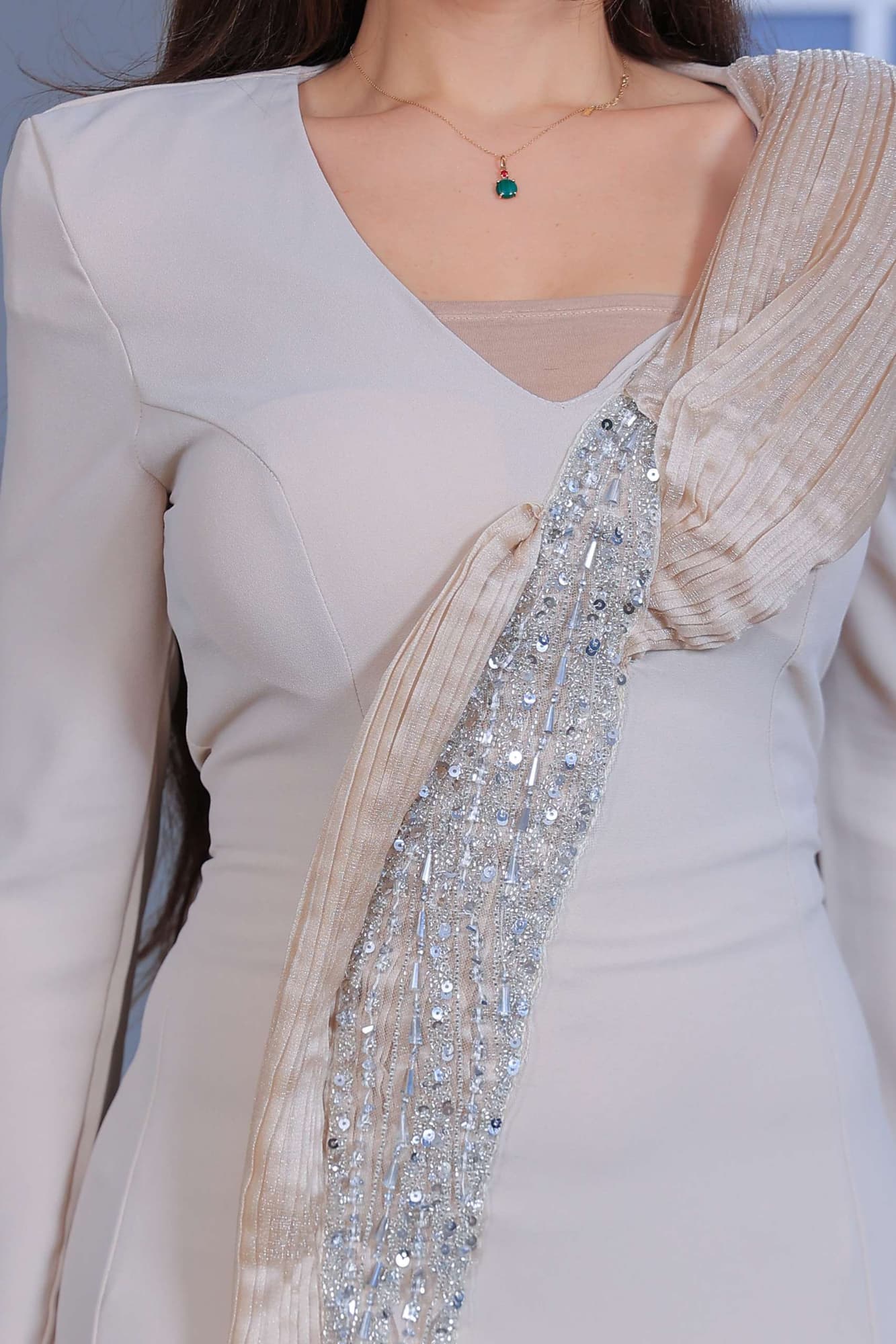 فستان سهرة طويل يتميز بقصّة مستقيمة تبرز القوام بانسيابية يعكس فخامة هادئة وأناقة عصرية بيج