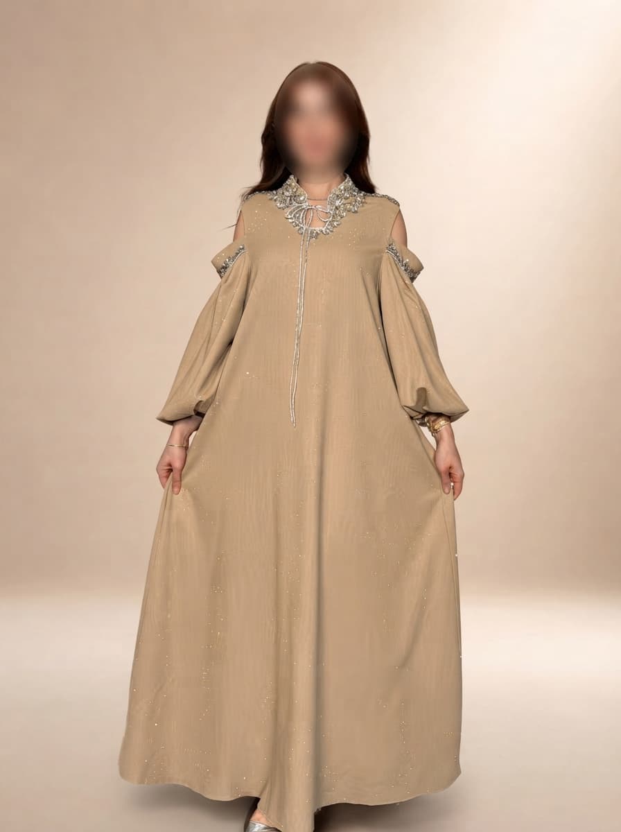 فستان طويل يتميّز بقصّة واسعة مريحة تنسدل بانسيابية أنثوية مع أكمام طويلة مفتوحة عند الكتفين تضيف لمسة عصرية راقية.