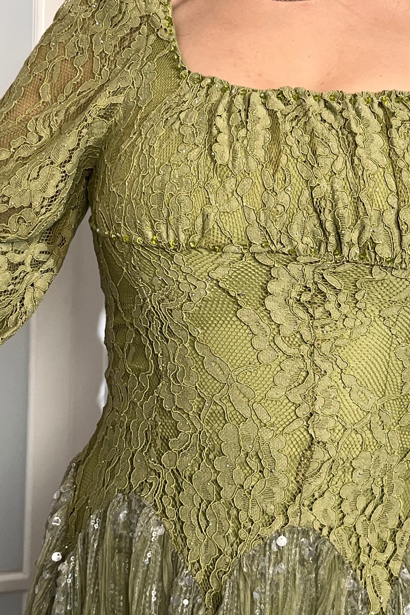 فستان ناعم صُمّم ليمنحك لمعة ساحرة بكل حركة من خامة الدانتيل مُطرّز بدقّة مع كورسية يبرز جمال القوام عشبي