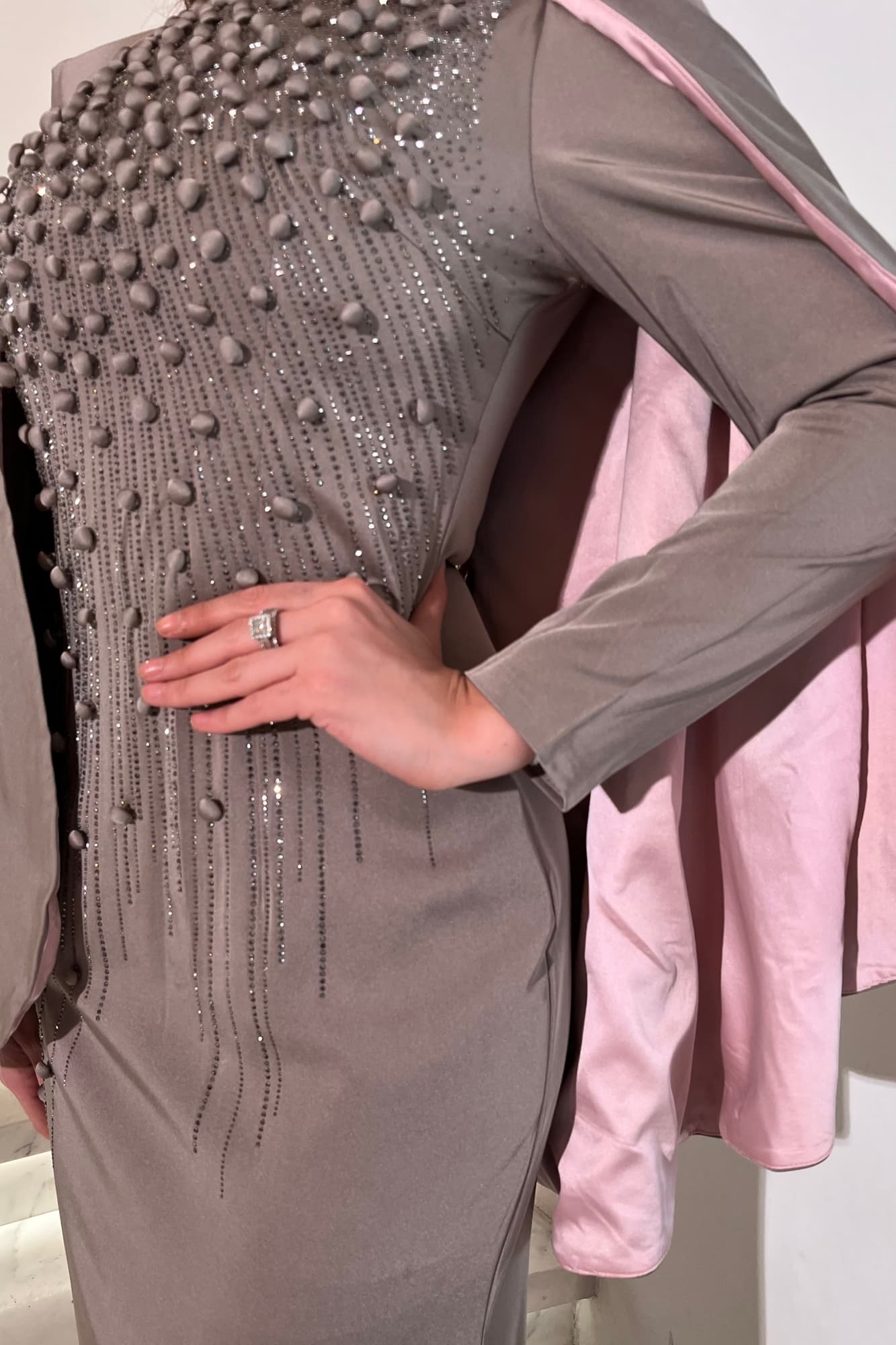 فستان سهرة راقٍ بقصّة مستقيمة تضفي طول وأناقة على الإطلالة مزين بتطريزات لامعة رصاصي