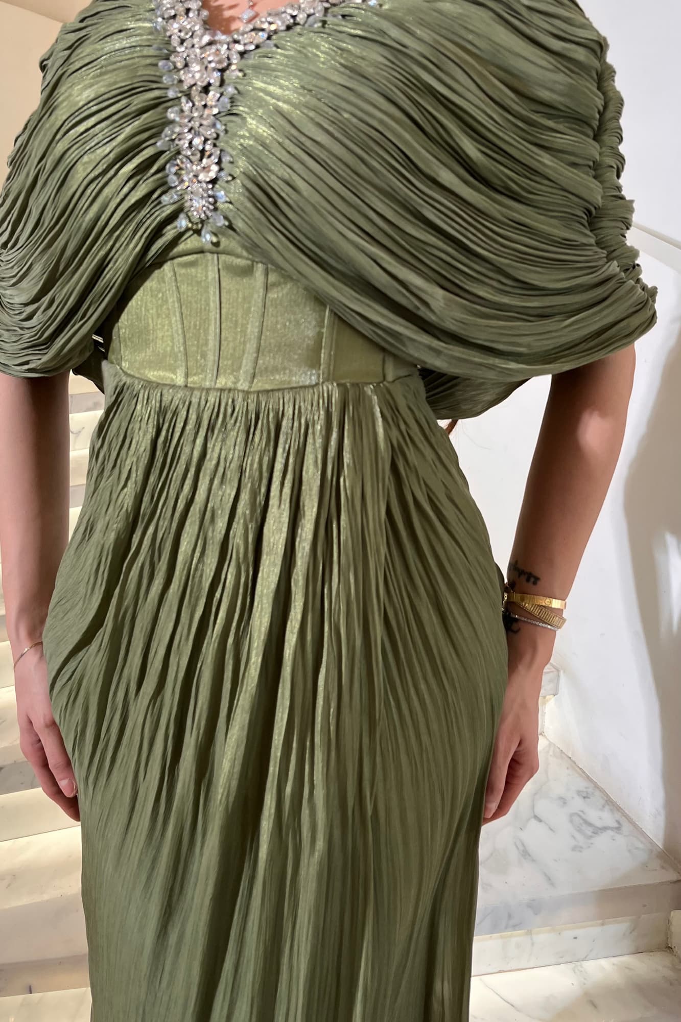 فستان سهرة يمنح إطلالة فاخرة وراقية مصنوع من قماش انسيابي خفيف بملمس ناعم وطيات حريرية متدرجة زيتي فاتح