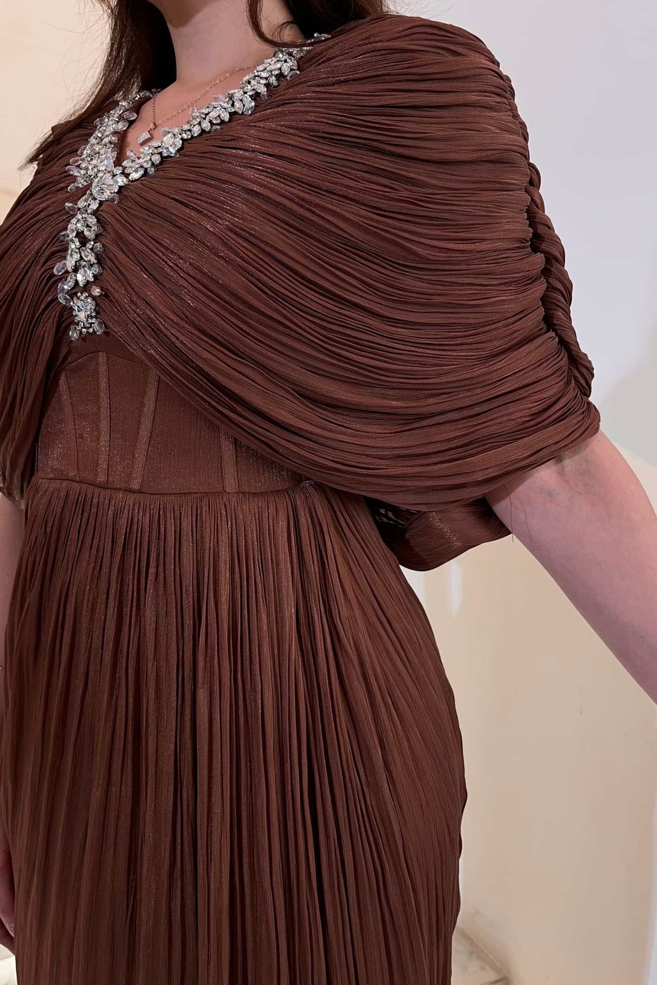 فستان سهرة يمنح إطلالة فاخرة وراقية مصنوع من قماش انسيابي خفيف بملمس ناعم وطيات حريرية متدرجة بني