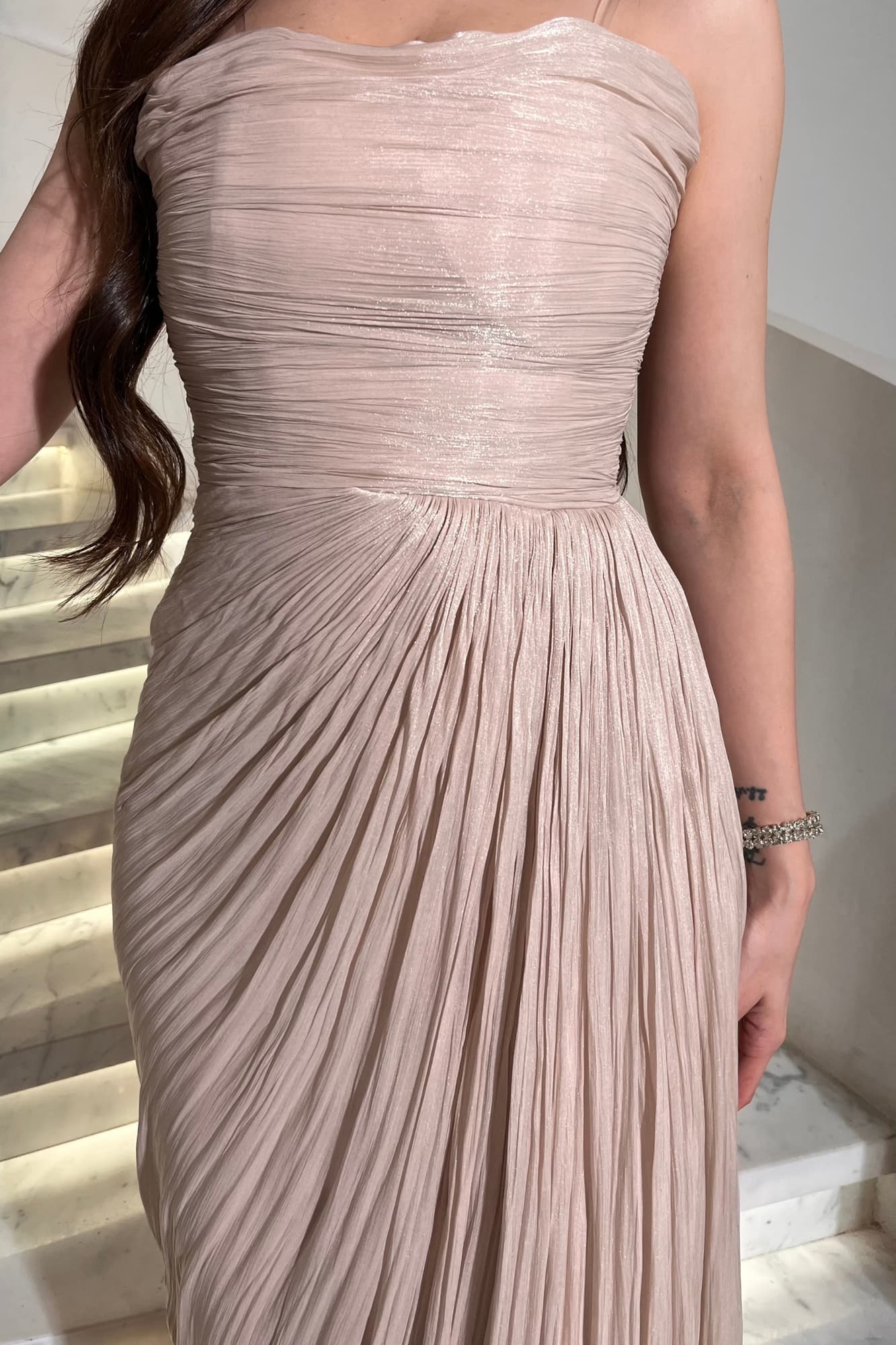 فستان سهرة ناعم يخطف الأنظار بأنوثته الهادئة مصمّم بطبقات درابية تبرز القوام بشكل ناعم بيج