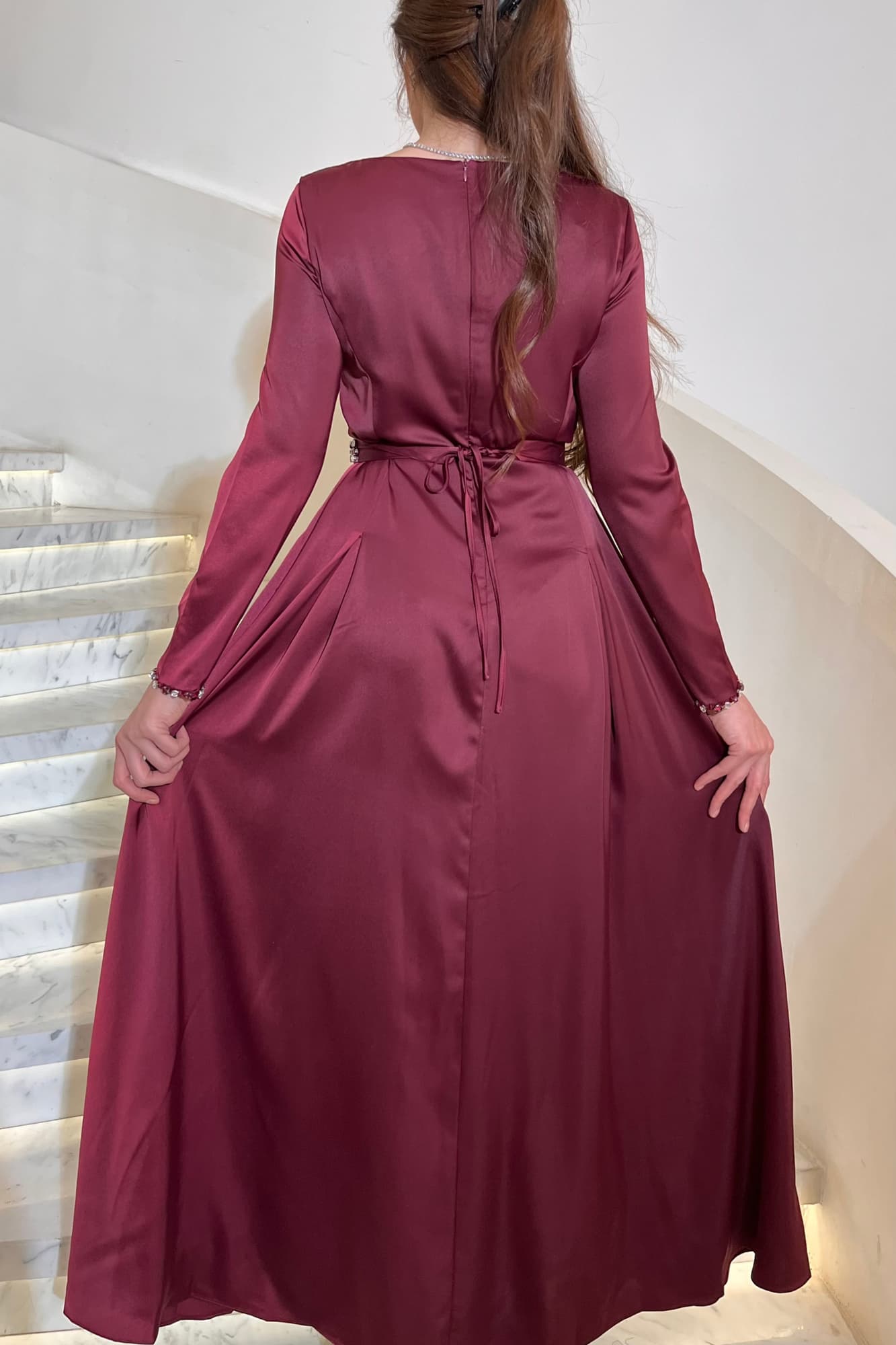 فستان ناعم فخم بتصميم طويل من قماش ساتان يتميّز بتطريز يدوي من الكريستالات اللامعة