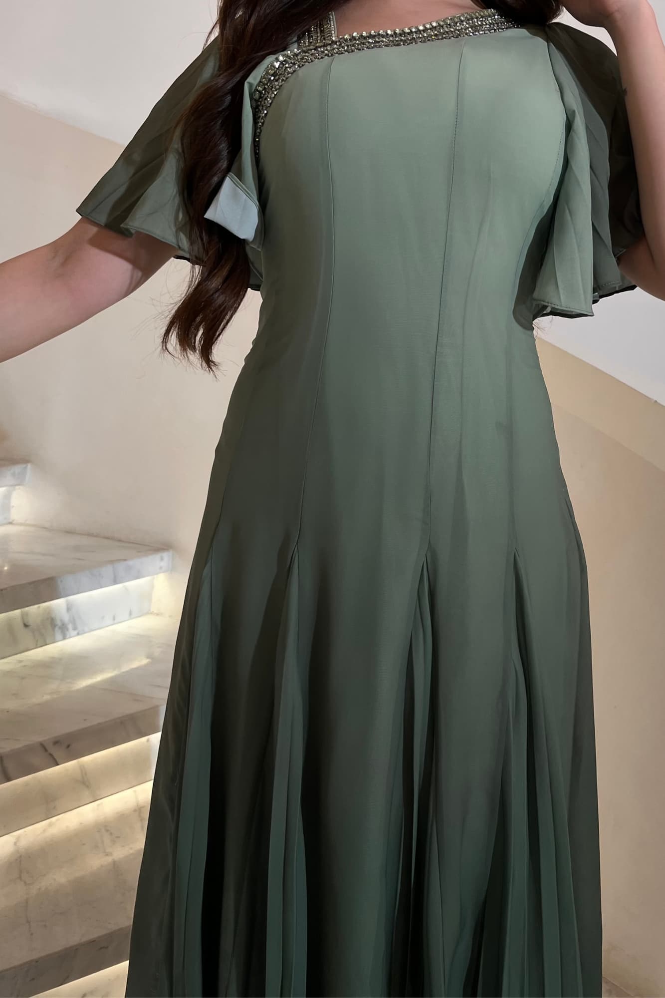 فستان سهرة انسيابي بلون أخضر ميرميّة هادئ بتصميم ناعم يُبرز أنوثة التفاصيل