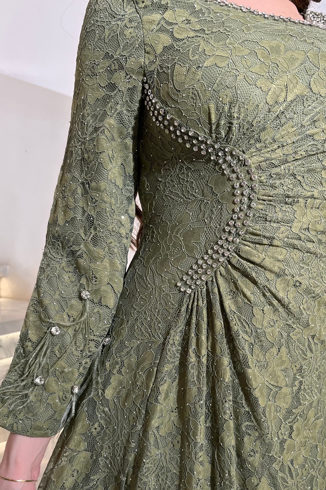 فستان ناعم فخم بتصميم أنثوي راقٍ. مصنوع من دانتيل مطرّز بالكريستالات الفضية زيتي فاتح