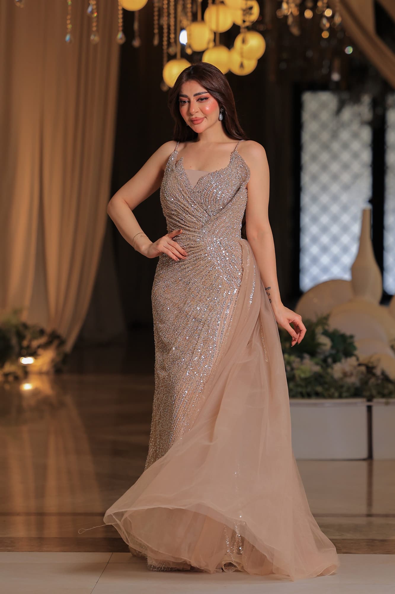 فستان سهرة فاخر بتصميم يُجسد الأناقة يتميز بقماش لامع مرصع بالكامل بالترتر البراق