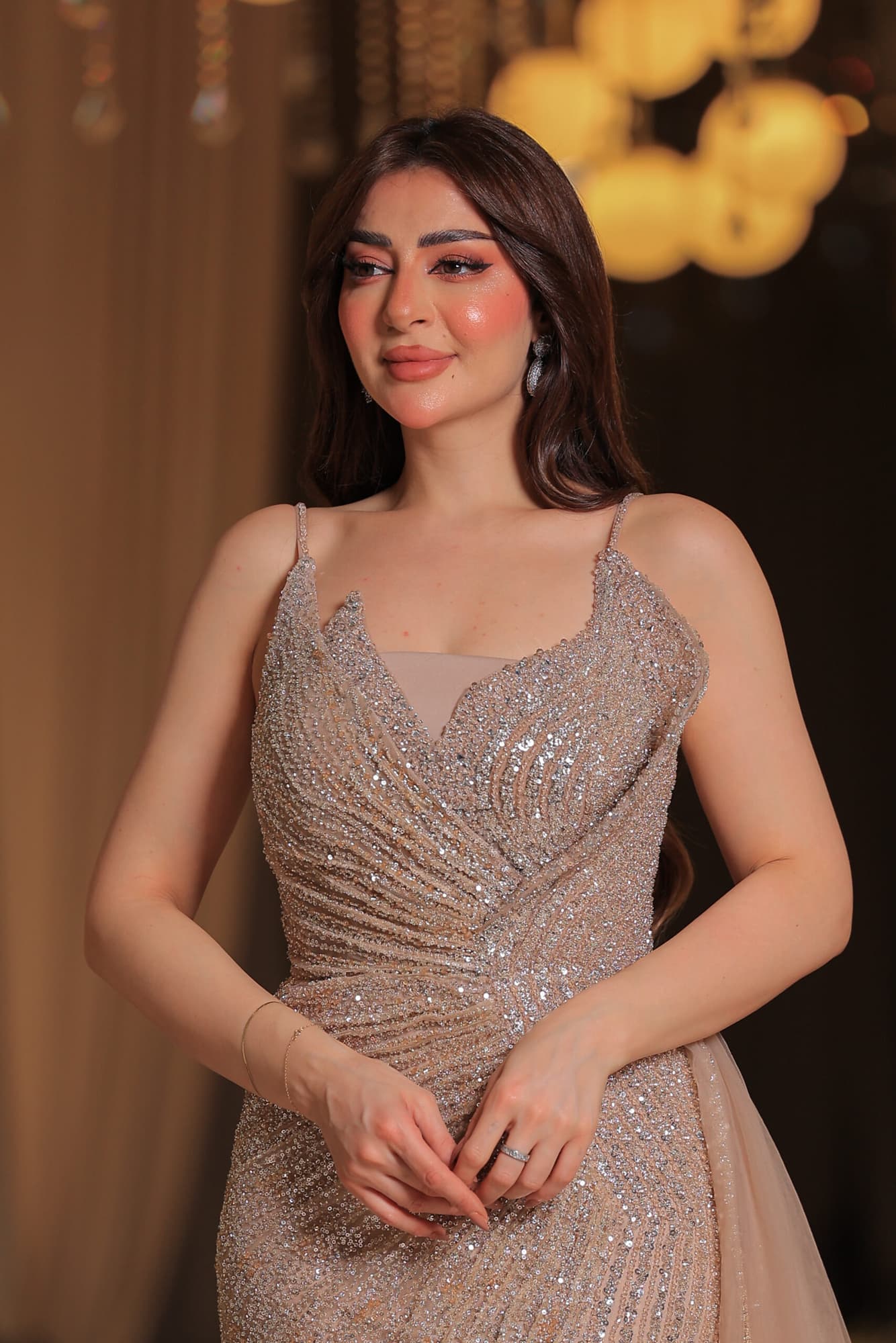 فستان سهرة فاخر بتصميم يُجسد الأناقة يتميز بقماش لامع مرصع بالكامل بالترتر البراق