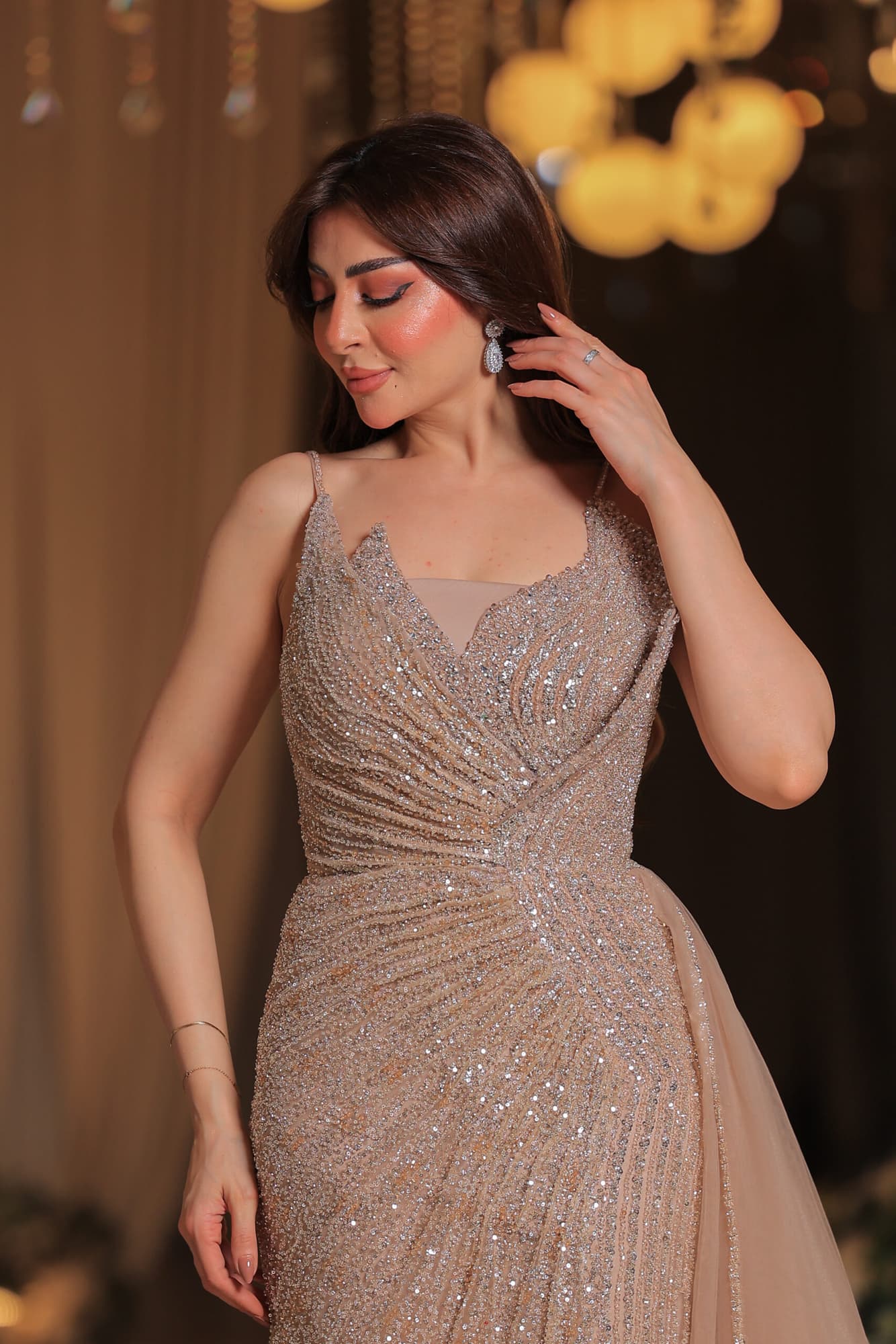 فستان سهرة فاخر بتصميم يُجسد الأناقة يتميز بقماش لامع مرصع بالكامل بالترتر البراق