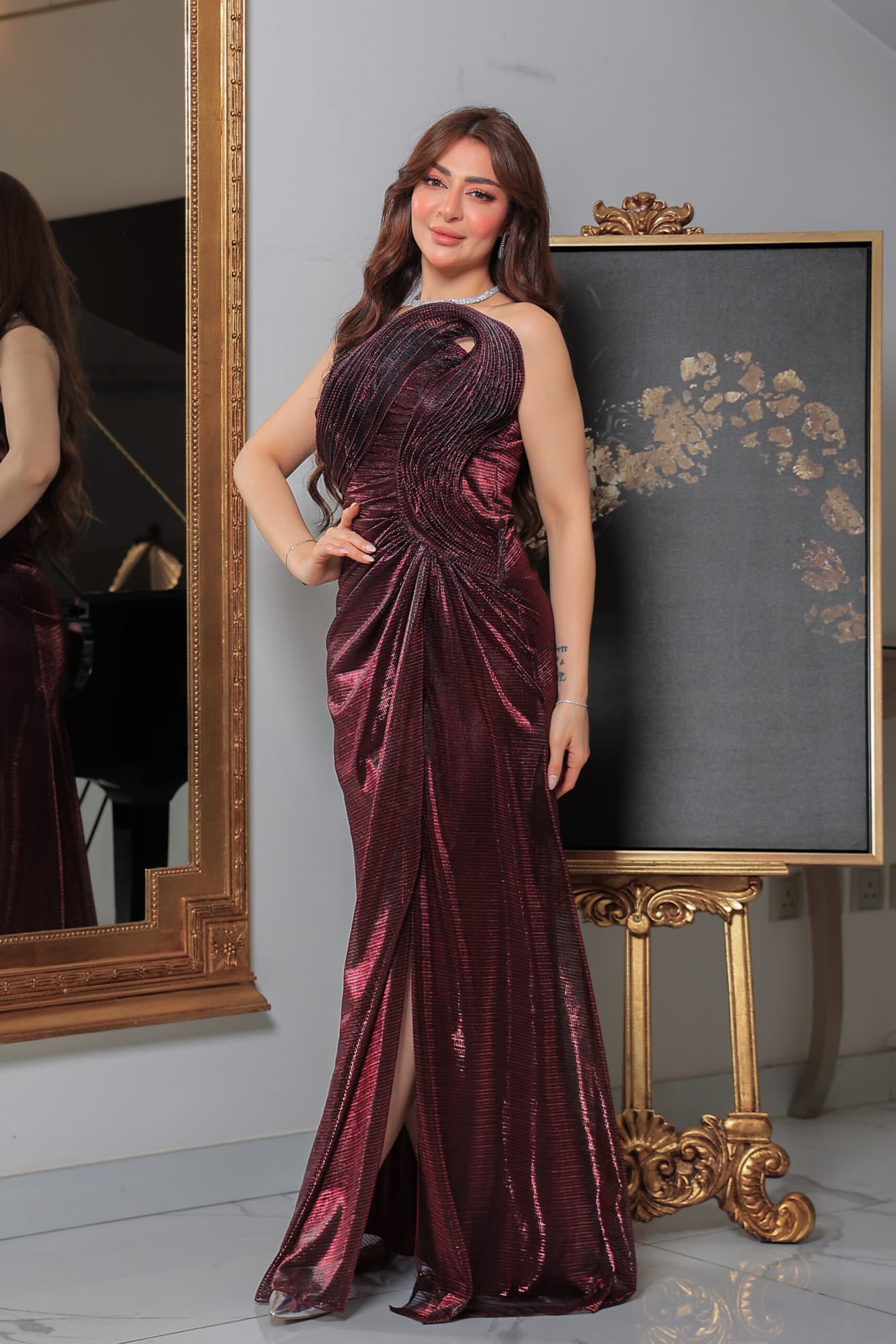 فستان سهرة لامع بفتحة ساق يتميز بقصة ضيّقة وتفاصيل درابيه فنية