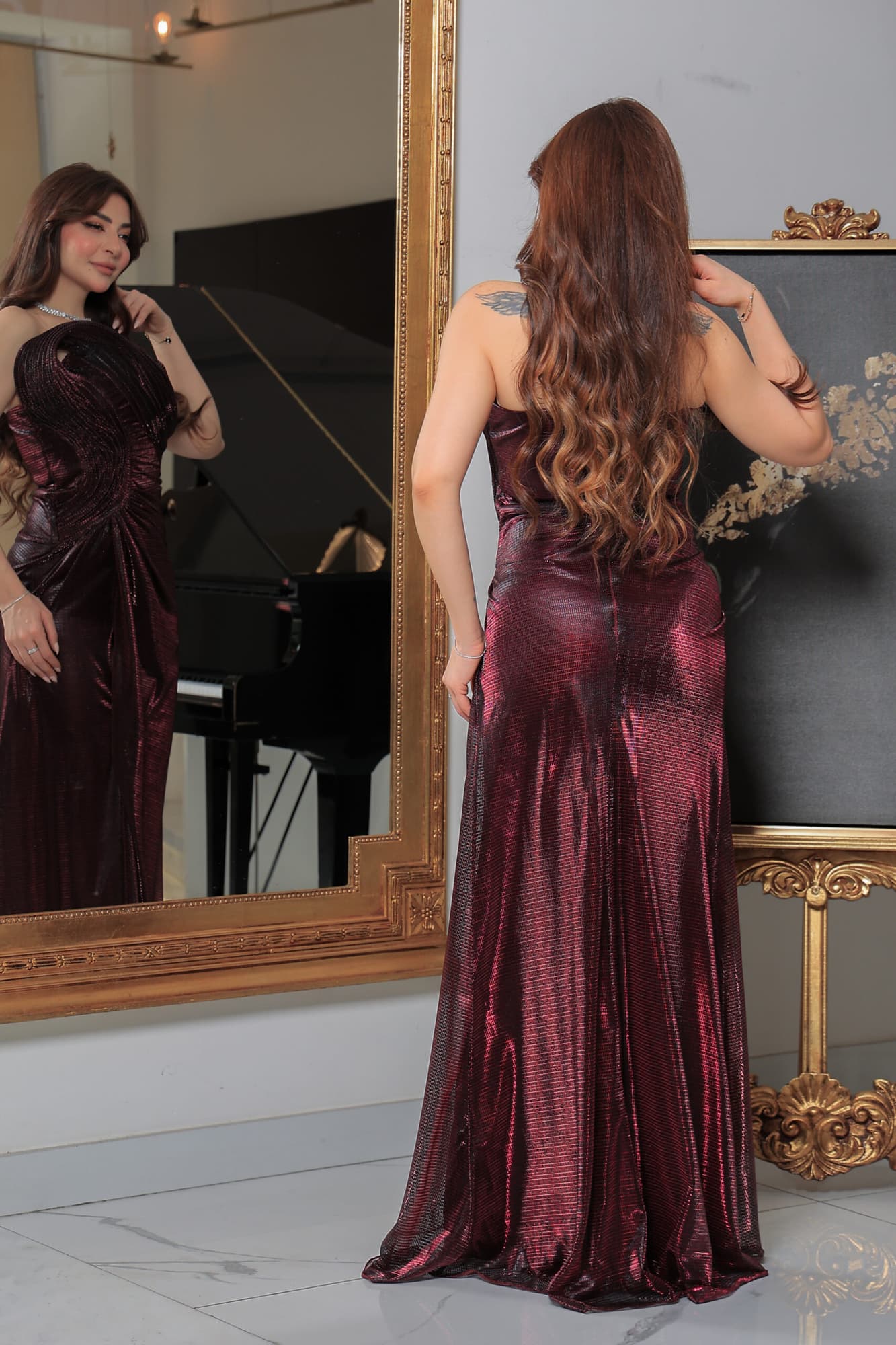 فستان سهرة لامع بفتحة ساق يتميز بقصة ضيّقة وتفاصيل درابيه فنية