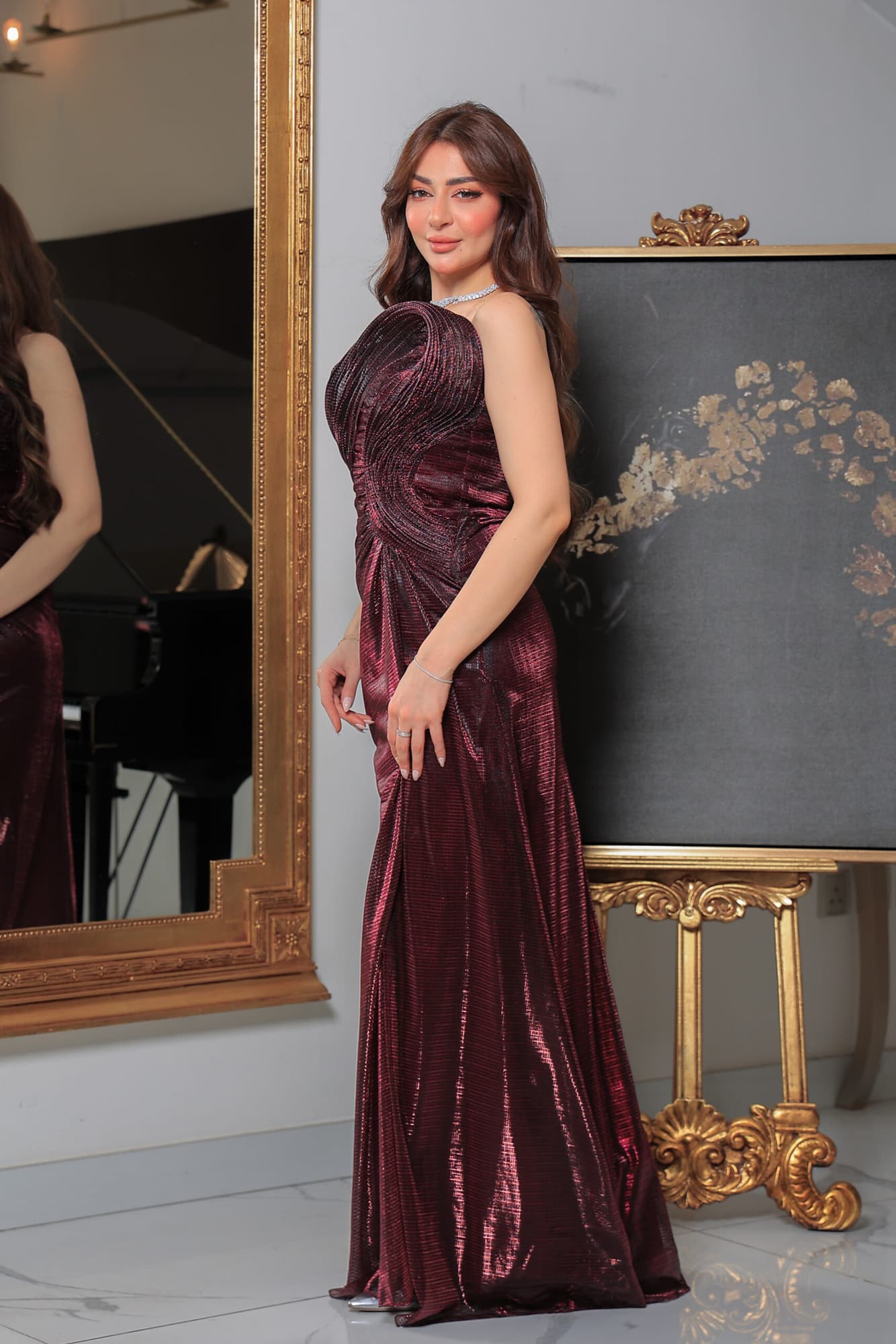 فستان سهرة لامع بفتحة ساق يتميز بقصة ضيّقة وتفاصيل درابيه فنية