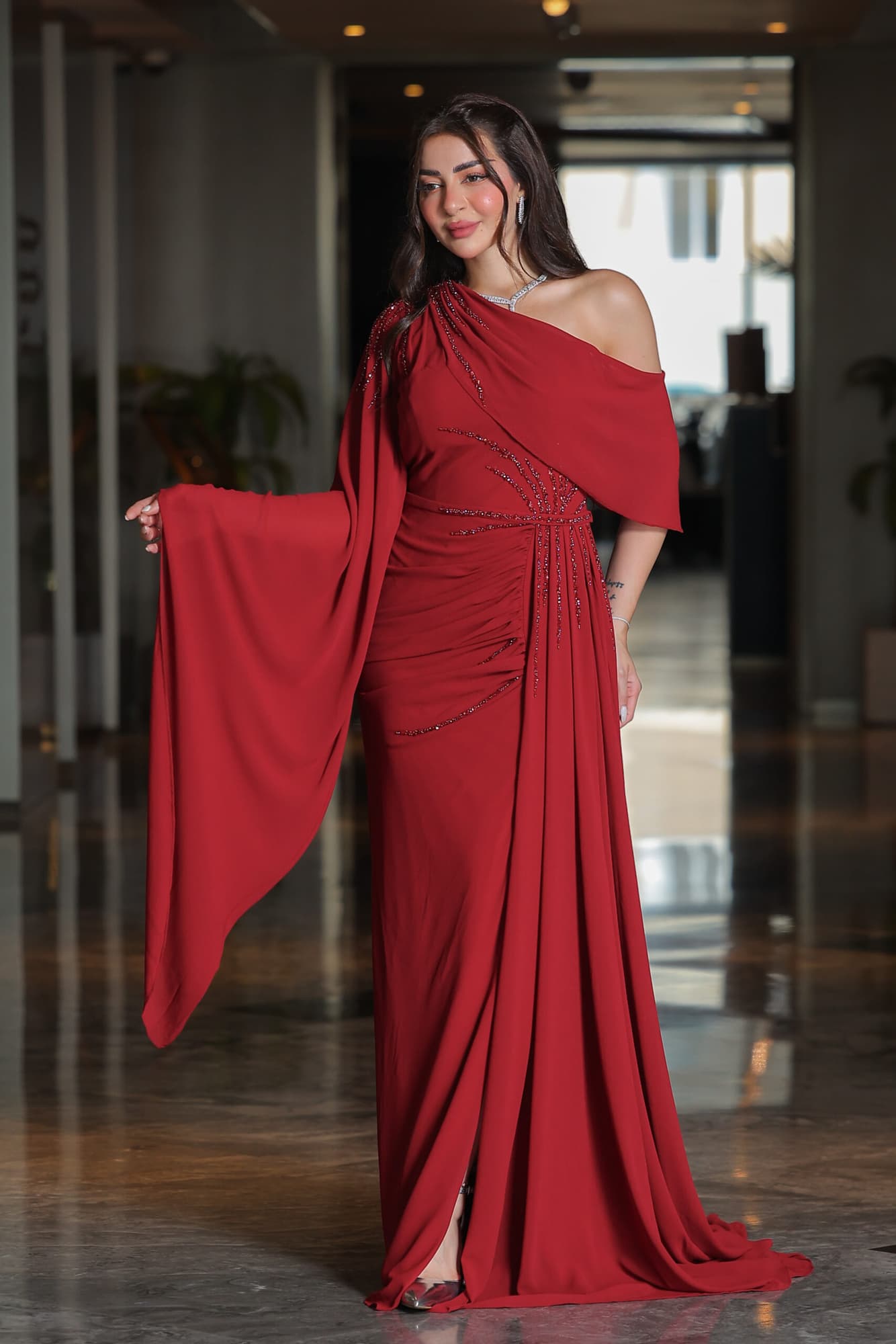 فستان سهرة بكم منسدل مزين بالكرستالات عودي