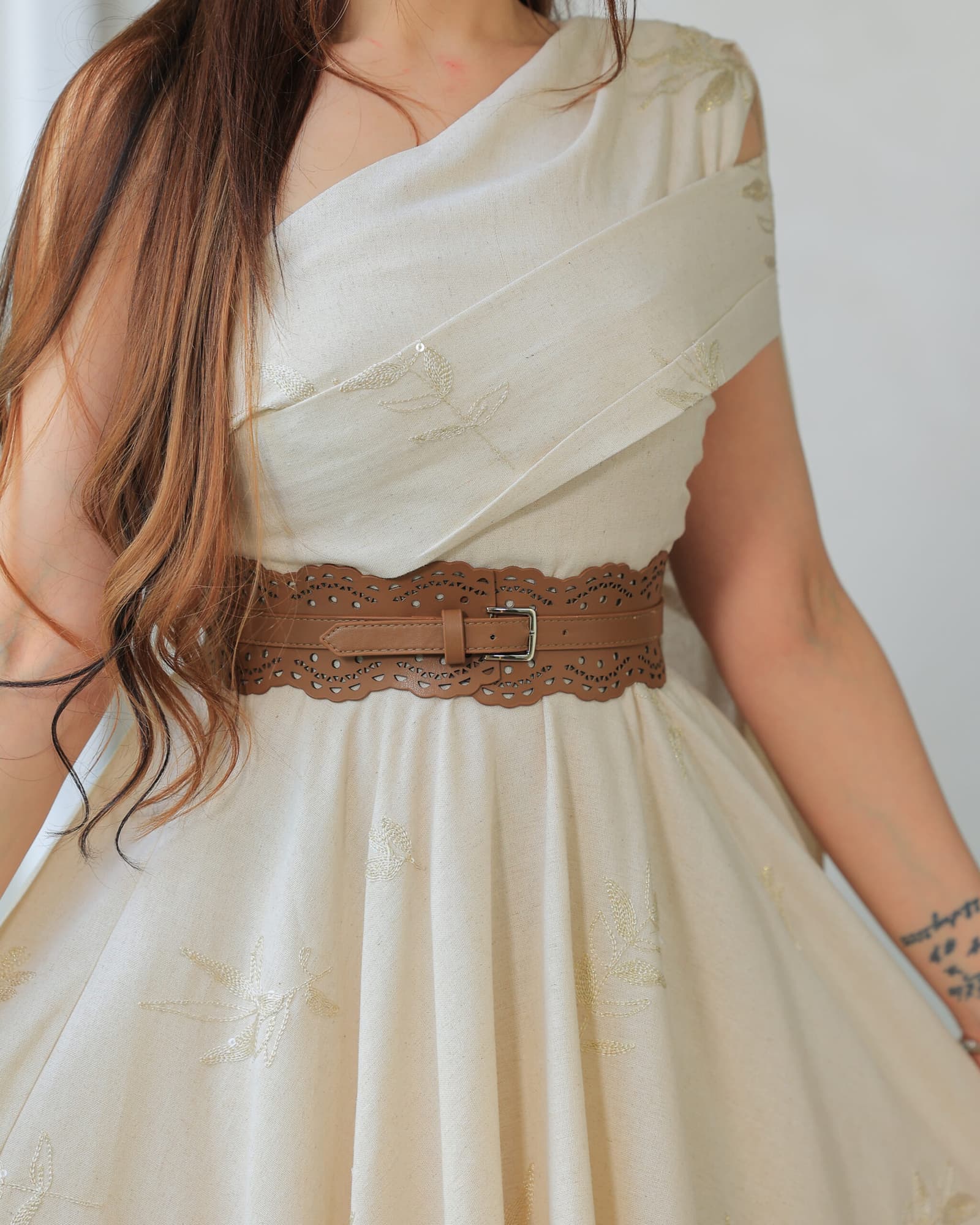 فستان راقٍ وأنيق يتميز بقصة غير متماثلة مع كتف مكشوف بيج فاتح