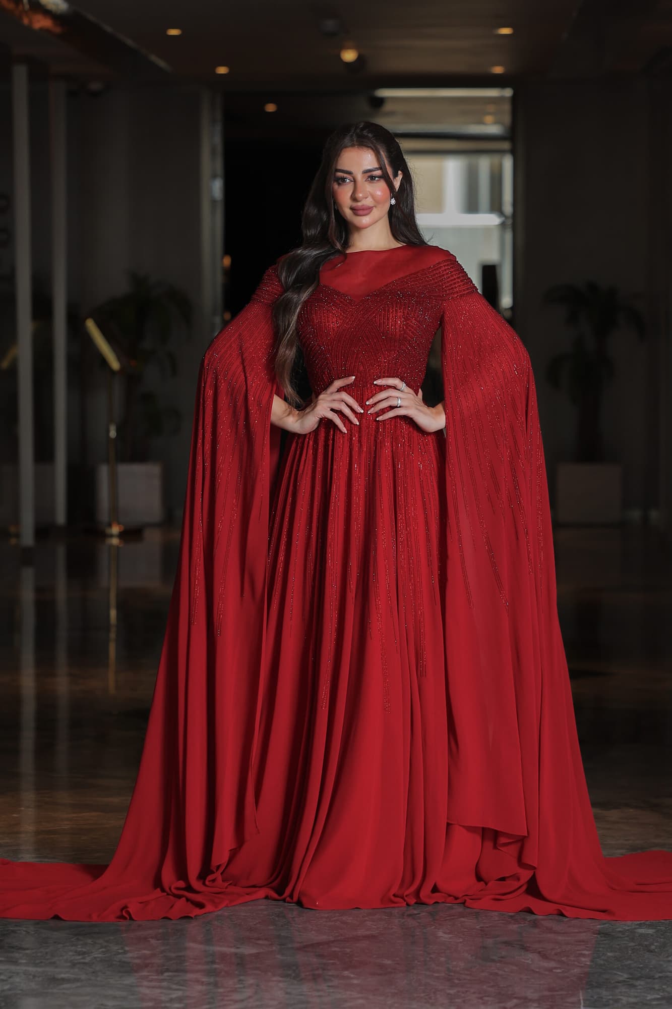 فستان سهرة أنيق مزين بفصوص براقة واكمام كيب