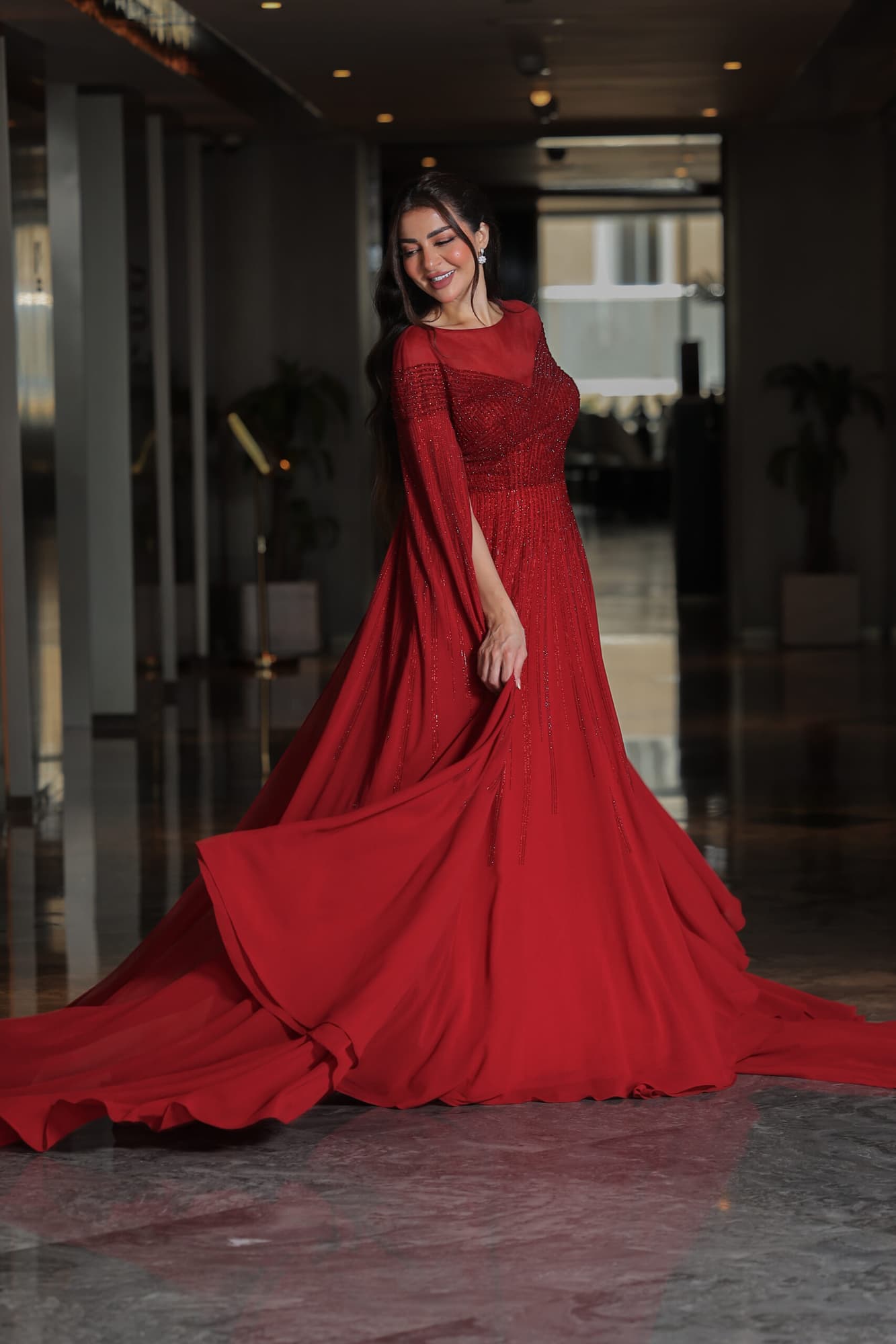 فستان سهرة أنيق مزين بفصوص براقة واكمام كيب