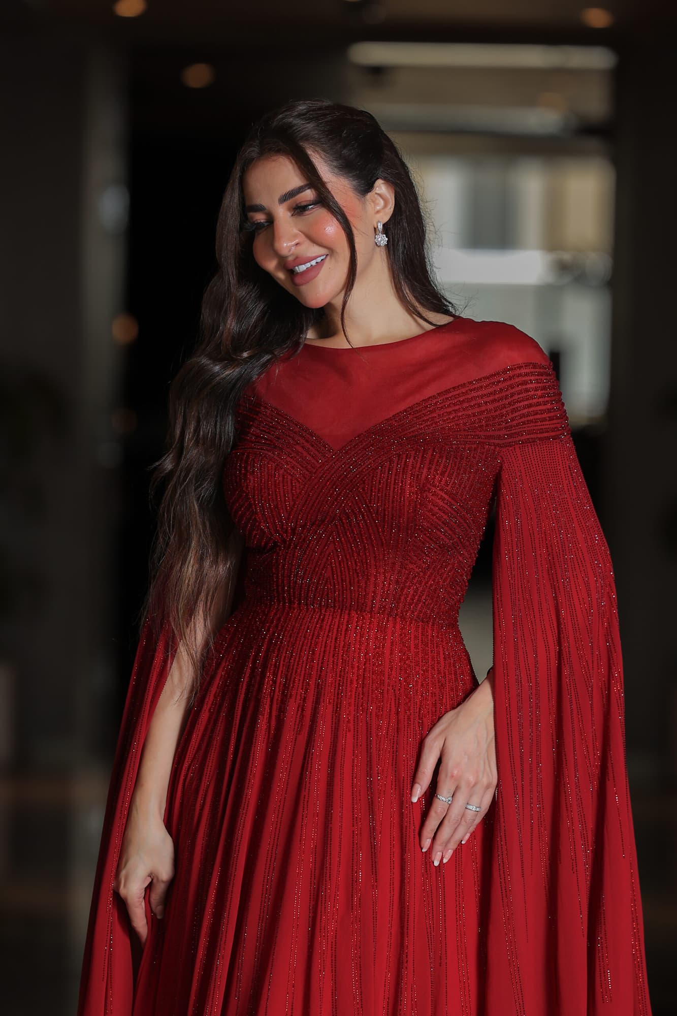 فستان سهرة أنيق مزين بفصوص براقة واكمام كيب