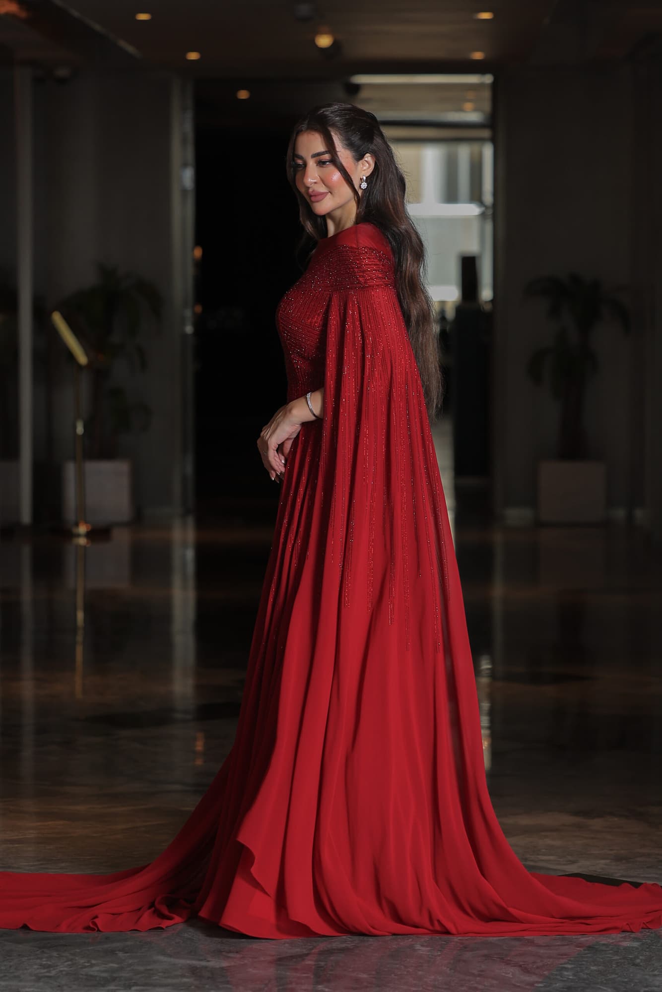 فستان سهرة أنيق مزين بفصوص براقة واكمام كيب