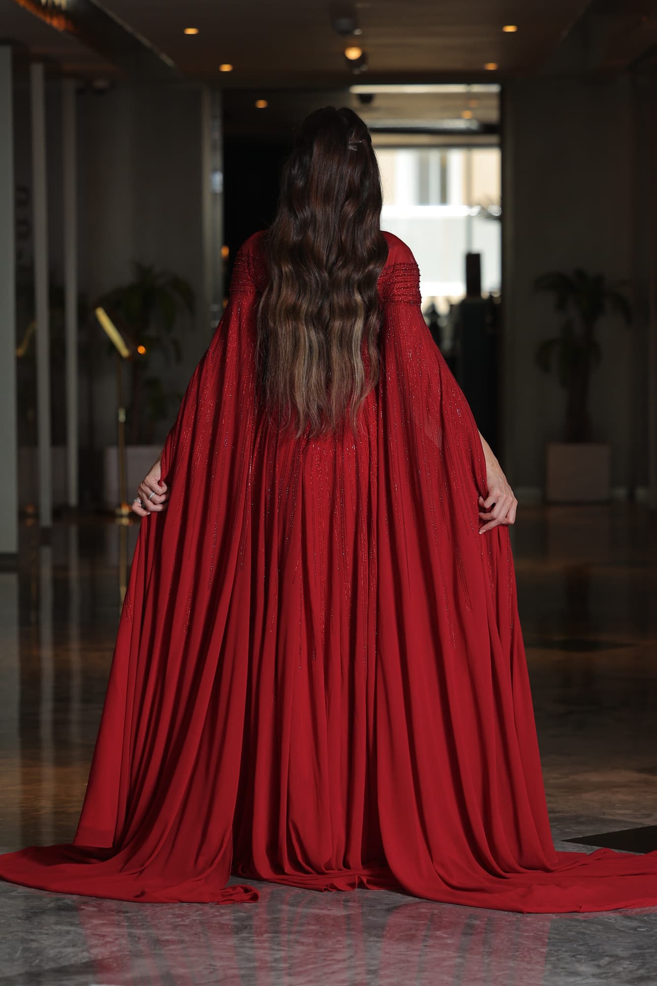 فستان سهرة أنيق مزين بفصوص براقة واكمام كيب