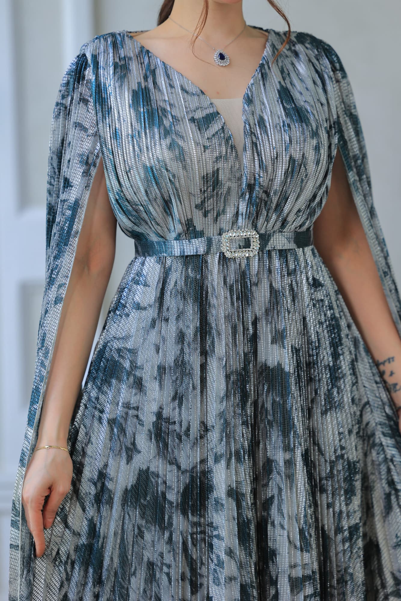 فستان أنيق يتميز بقصة انسيابية مع أكمام كيب اخضر غامق