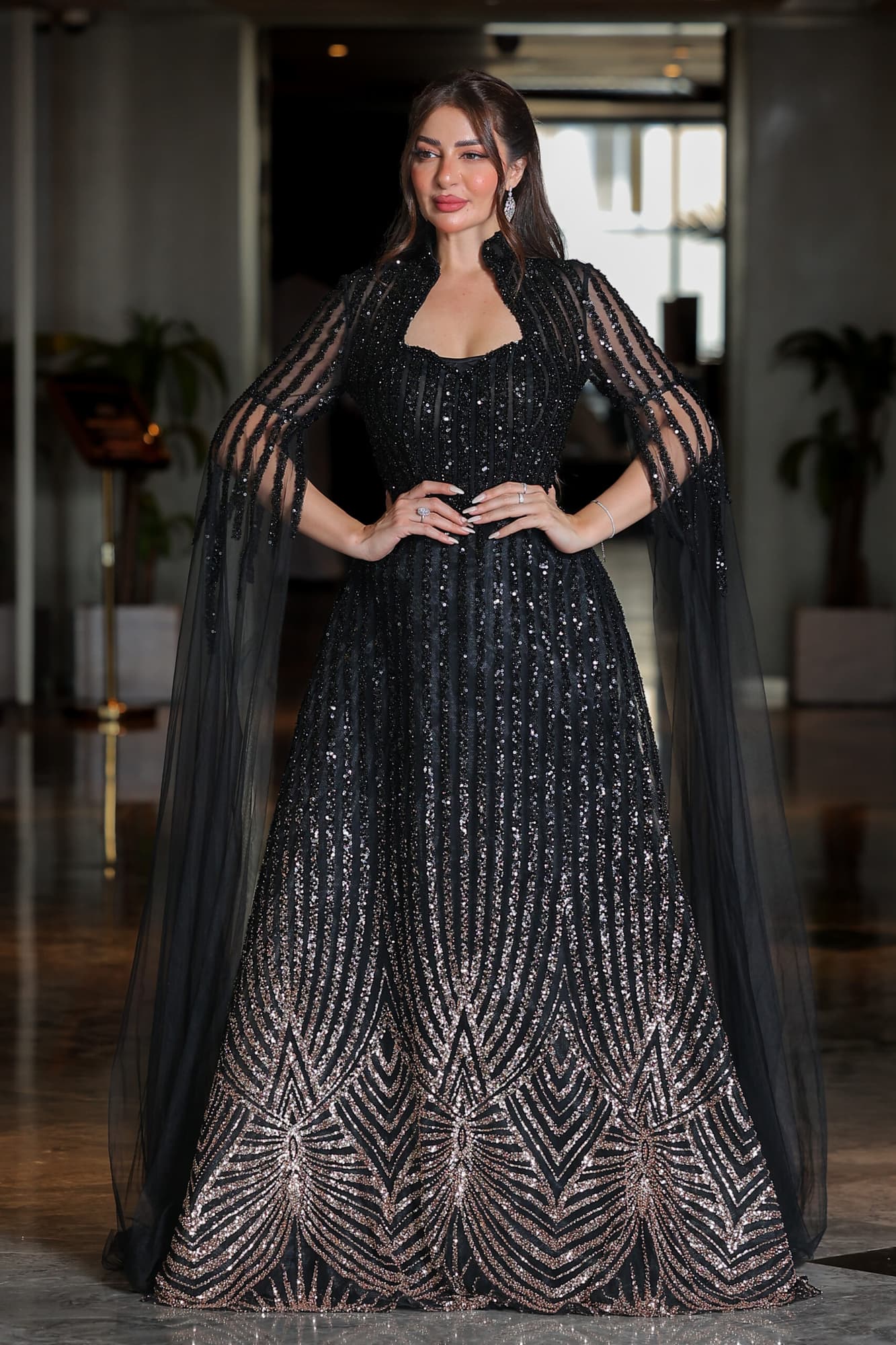 فستان سهرة مطرز بترتر وخرز بتدخيلة اللون البرونز بياقة عالية