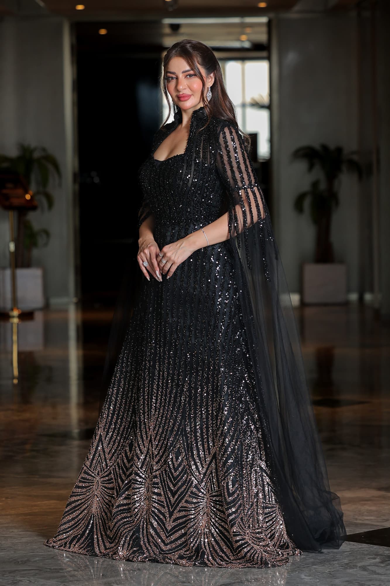 فستان سهرة مطرز بترتر وخرز بتدخيلة اللون البرونز بياقة عالية