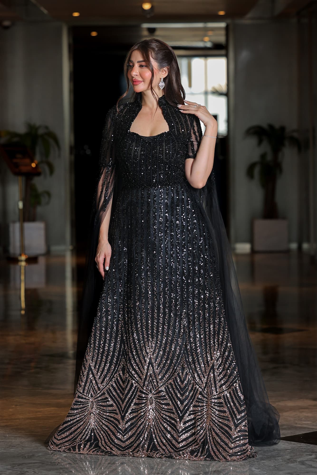 فستان سهرة مطرز بترتر وخرز بتدخيلة اللون البرونز بياقة عالية