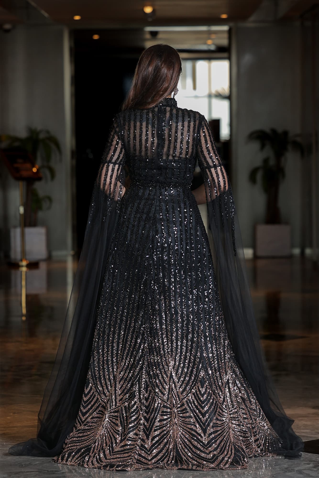 فستان سهرة مطرز بترتر وخرز بتدخيلة اللون البرونز بياقة عالية