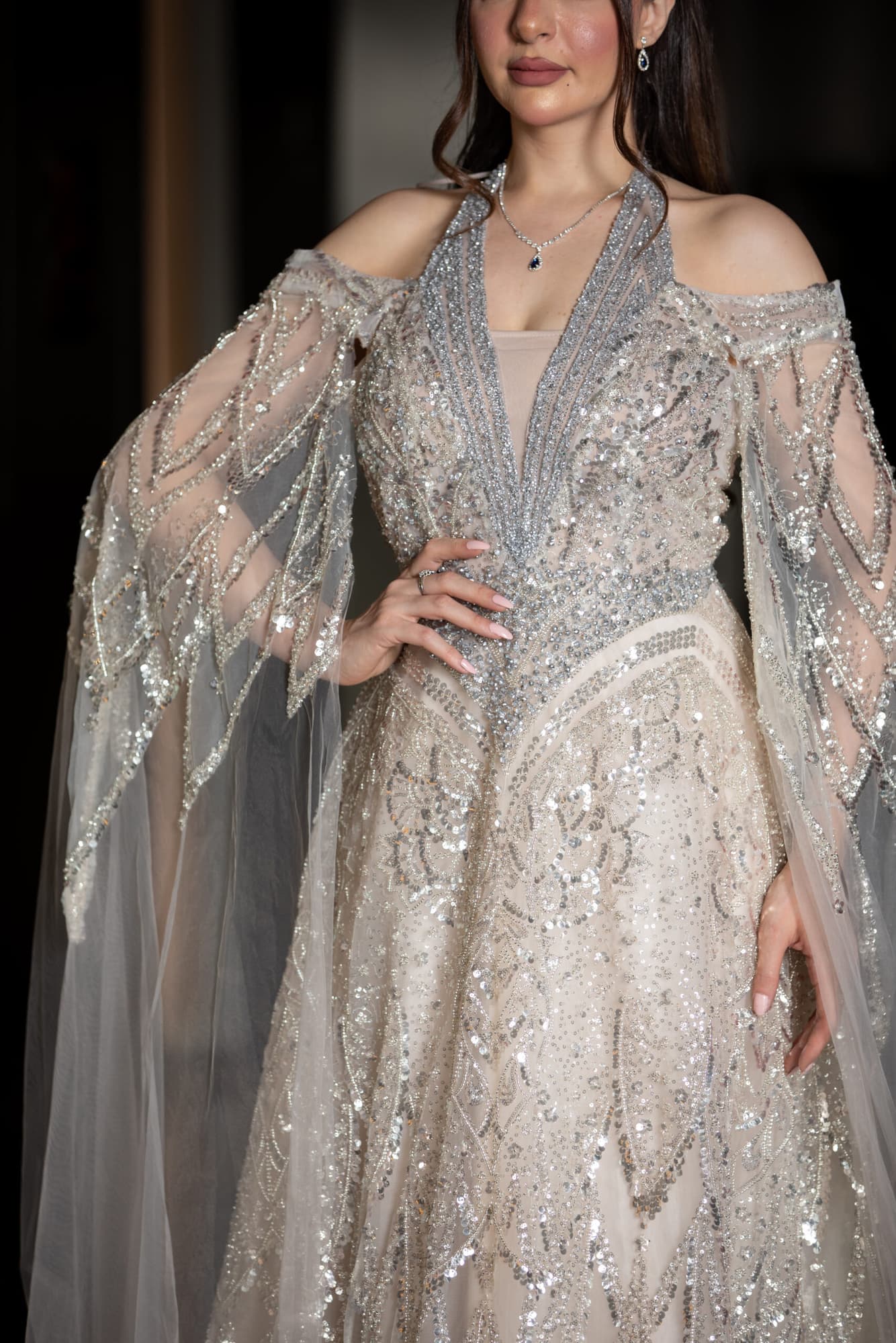 فستان سهره ملكي باكمام كيب مزخرف ومسكه رقبه اوف وايت