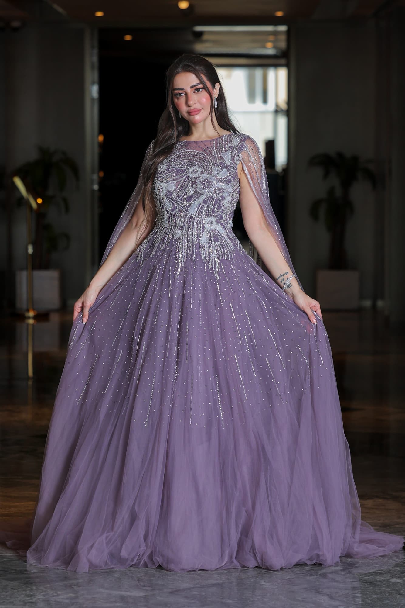 فستان سهرة مطرز بخرز وترتر على شكل ورود مصمم بأكمام كيب