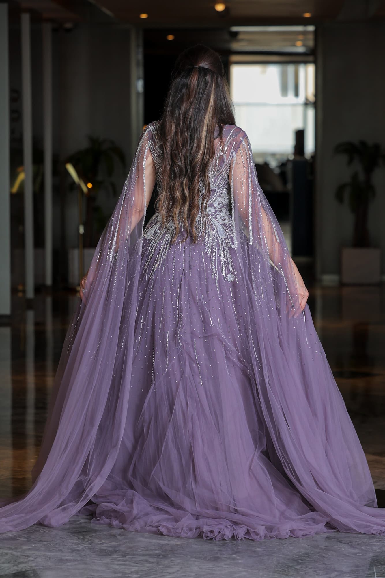 فستان سهرة مطرز بخرز وترتر على شكل ورود مصمم بأكمام كيب