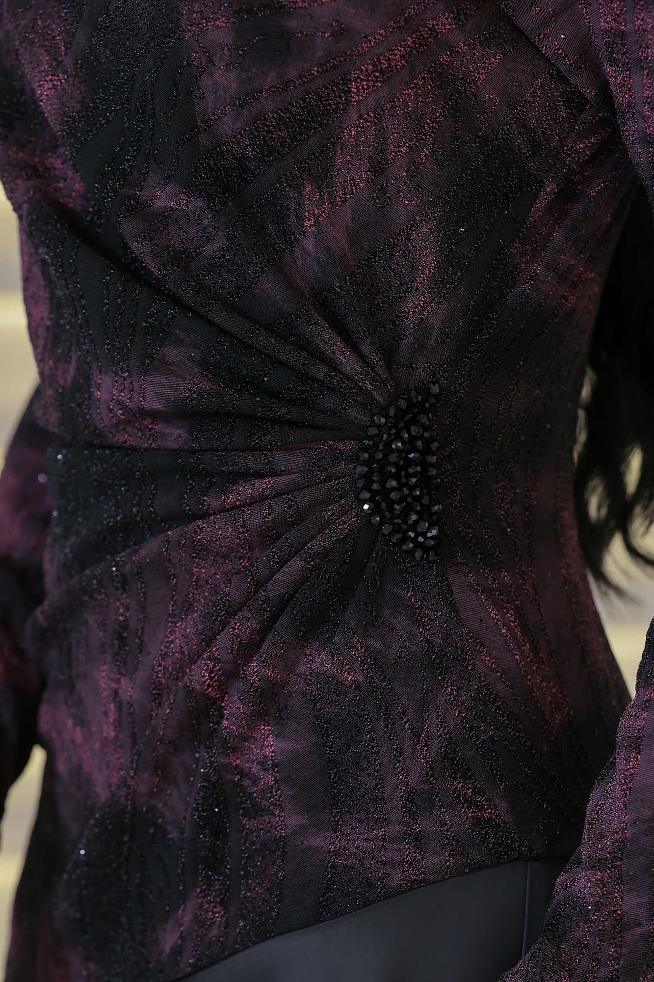 فستان أنيق يجمع بين الغموض والرقي يتميز الجزء العلوي بقماش داكن مع لمعة خفيفة ونقشة فنية