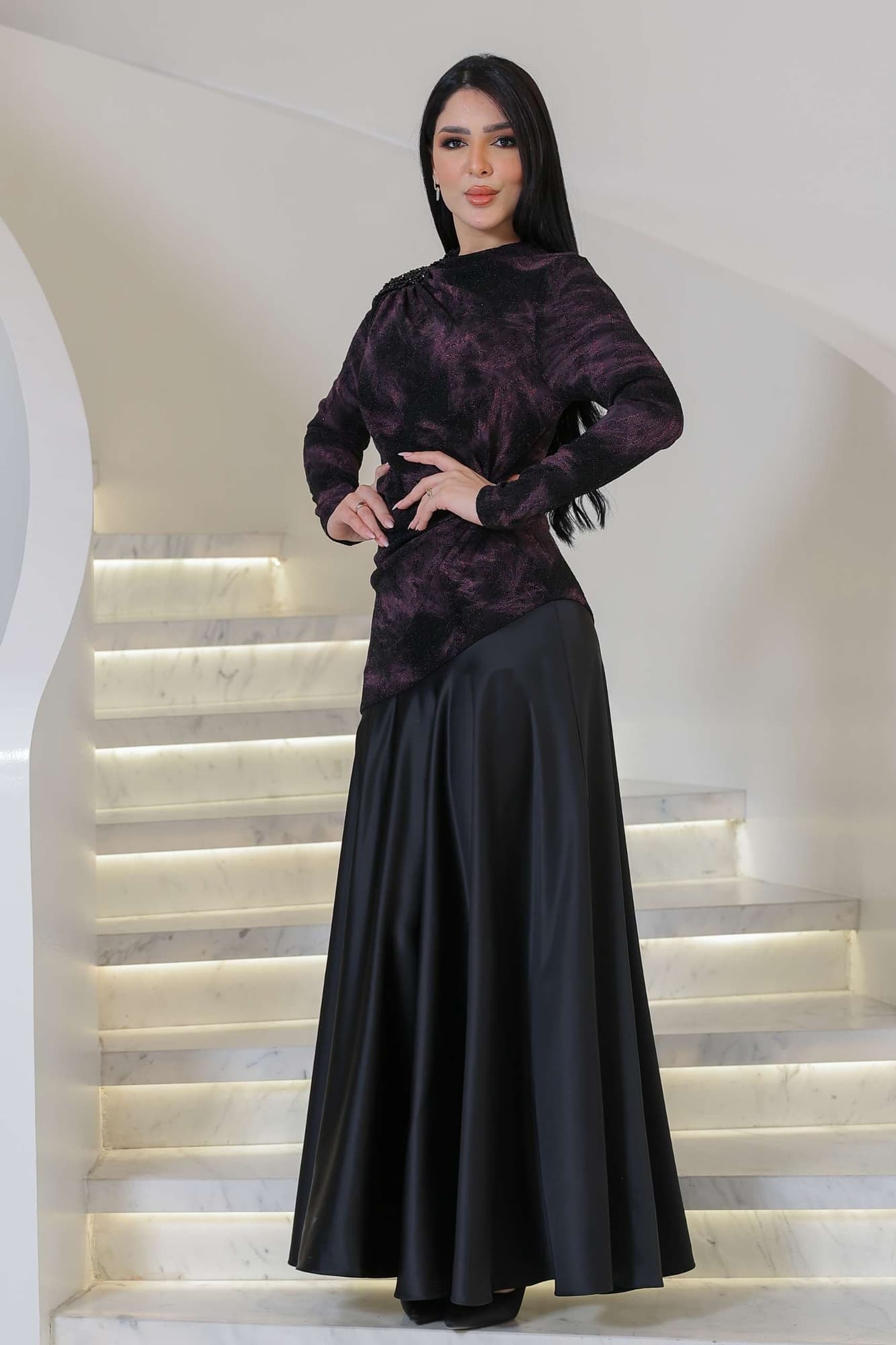 فستان أنيق يجمع بين الغموض والرقي يتميز الجزء العلوي بقماش داكن مع لمعة خفيفة ونقشة فنية