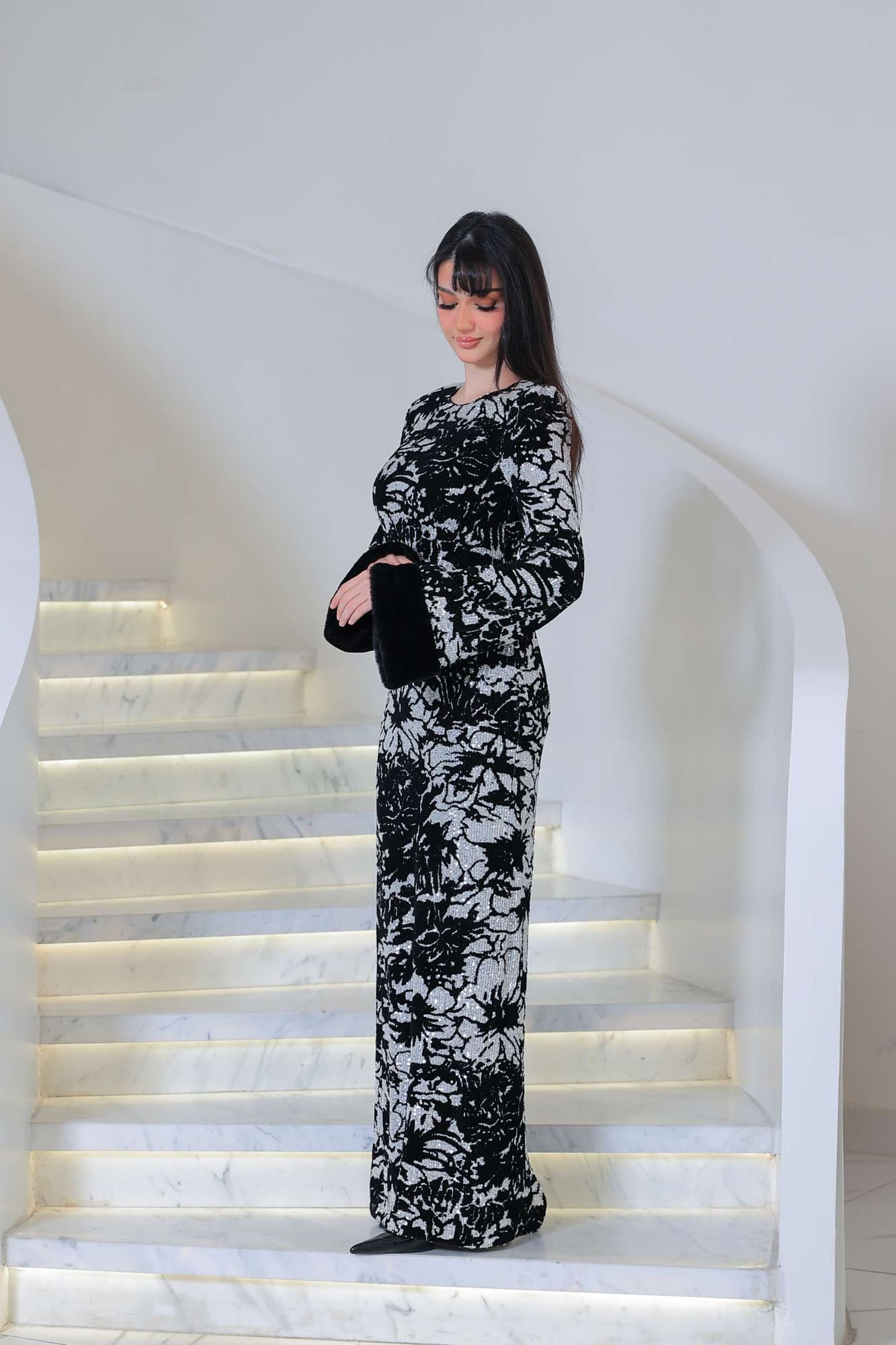 فستان أنيق بطابع راقٍ، يجمع بين اللون الأسود العميق ونقشات فضية مستوحاة من الزهور