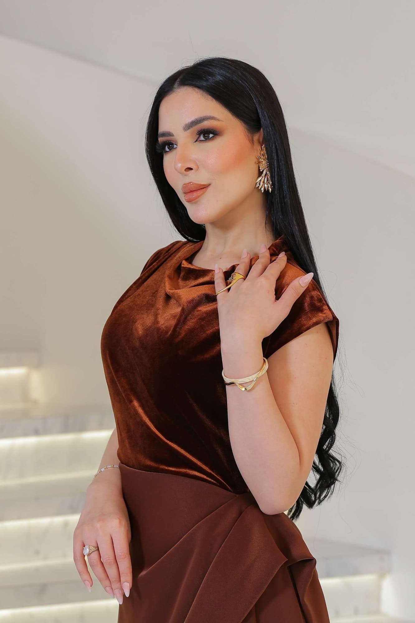 فستان يجمع بين نعومة المخمل في الجزء العلوي وانسيابية قماش الساتان في الاسفل ليخلق تباينًا غنيًا بالفخامة والأنوثة.