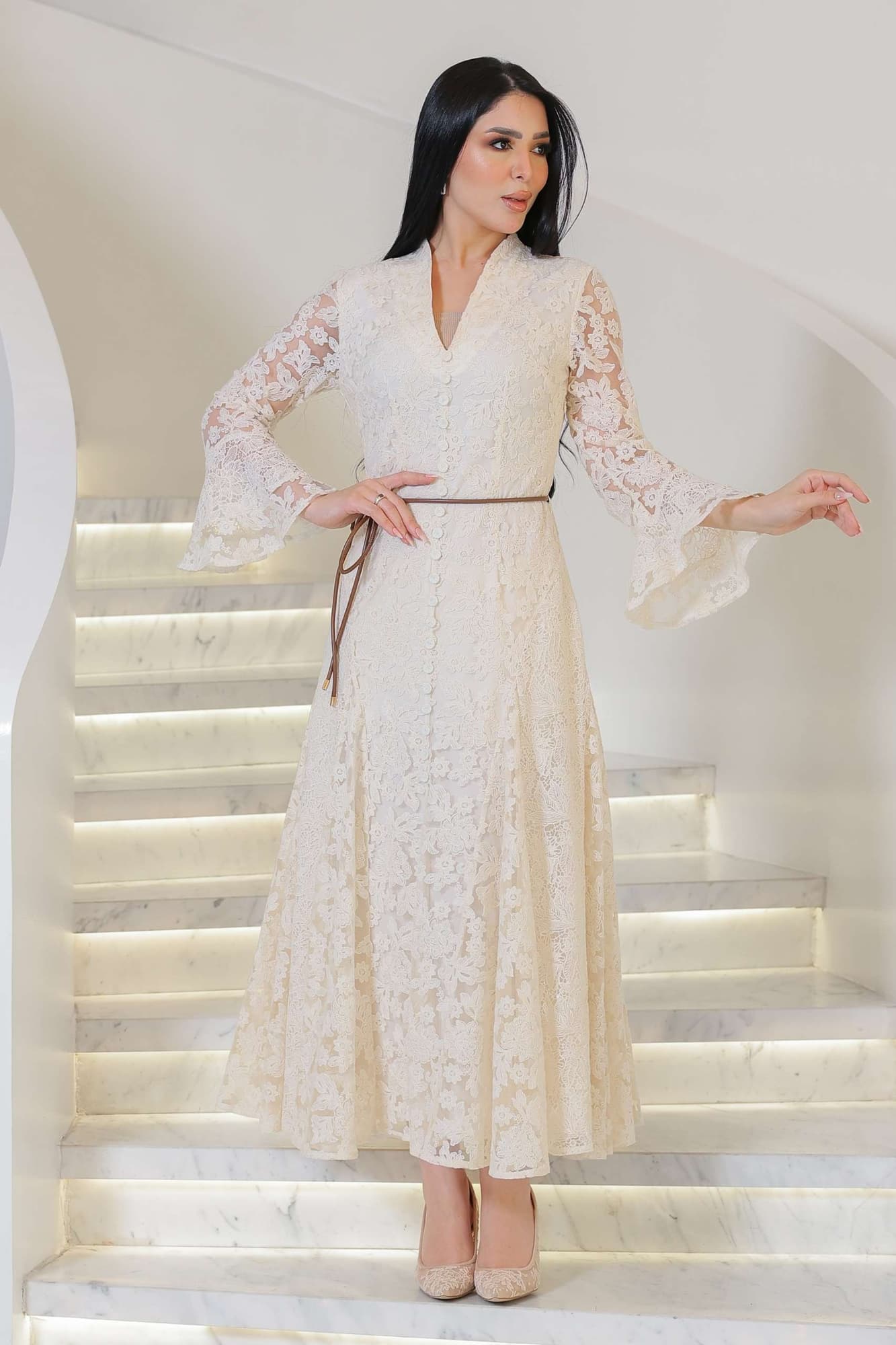 فستان أنثوي راقٍ يجمع بين البساطة والفخامة، مصنوع من دانتيل ناعم بلون أوف وايت يعكس إحساس الرقي