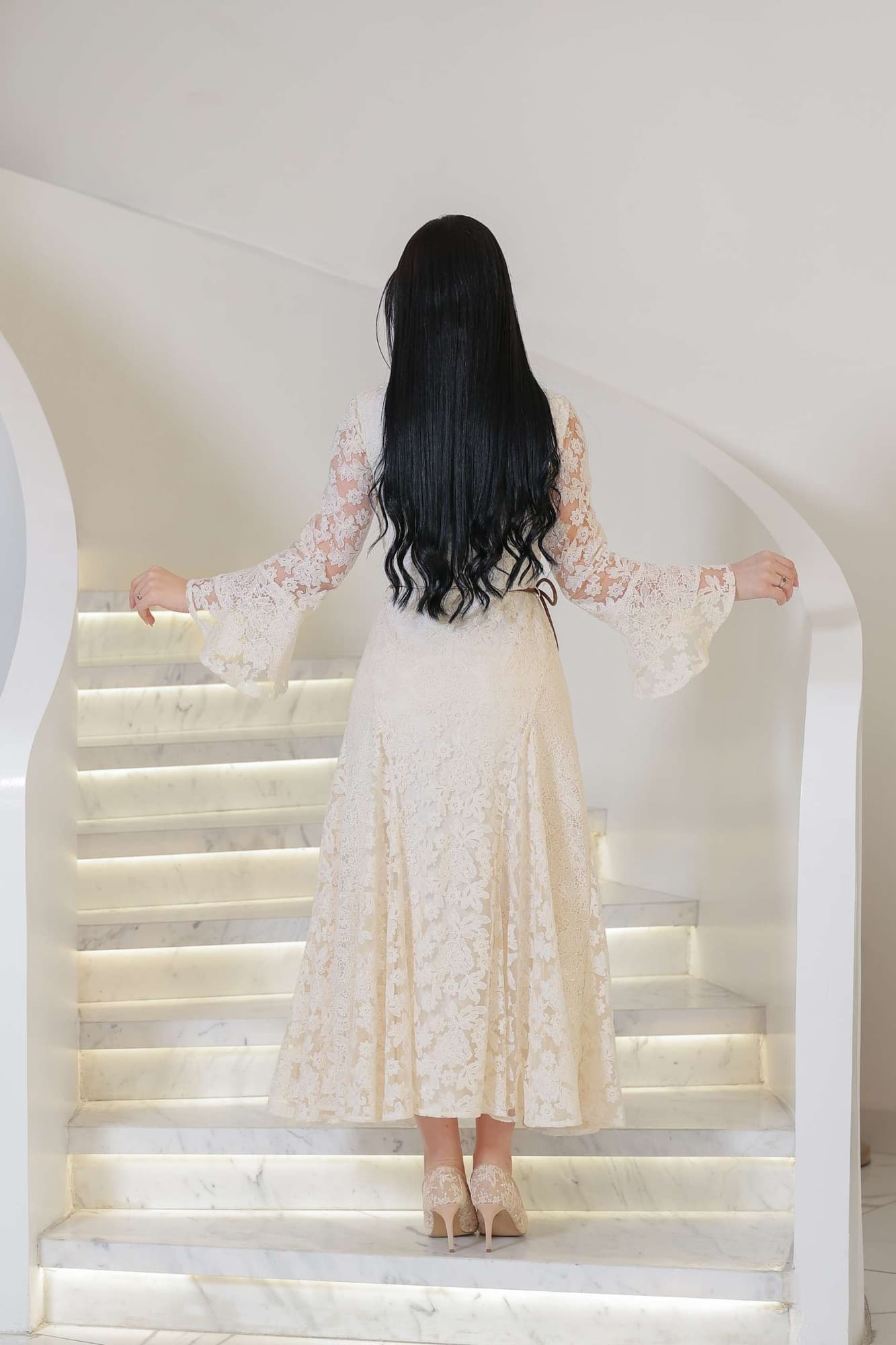 فستان أنثوي راقٍ يجمع بين البساطة والفخامة، مصنوع من دانتيل ناعم بلون أوف وايت يعكس إحساس الرقي