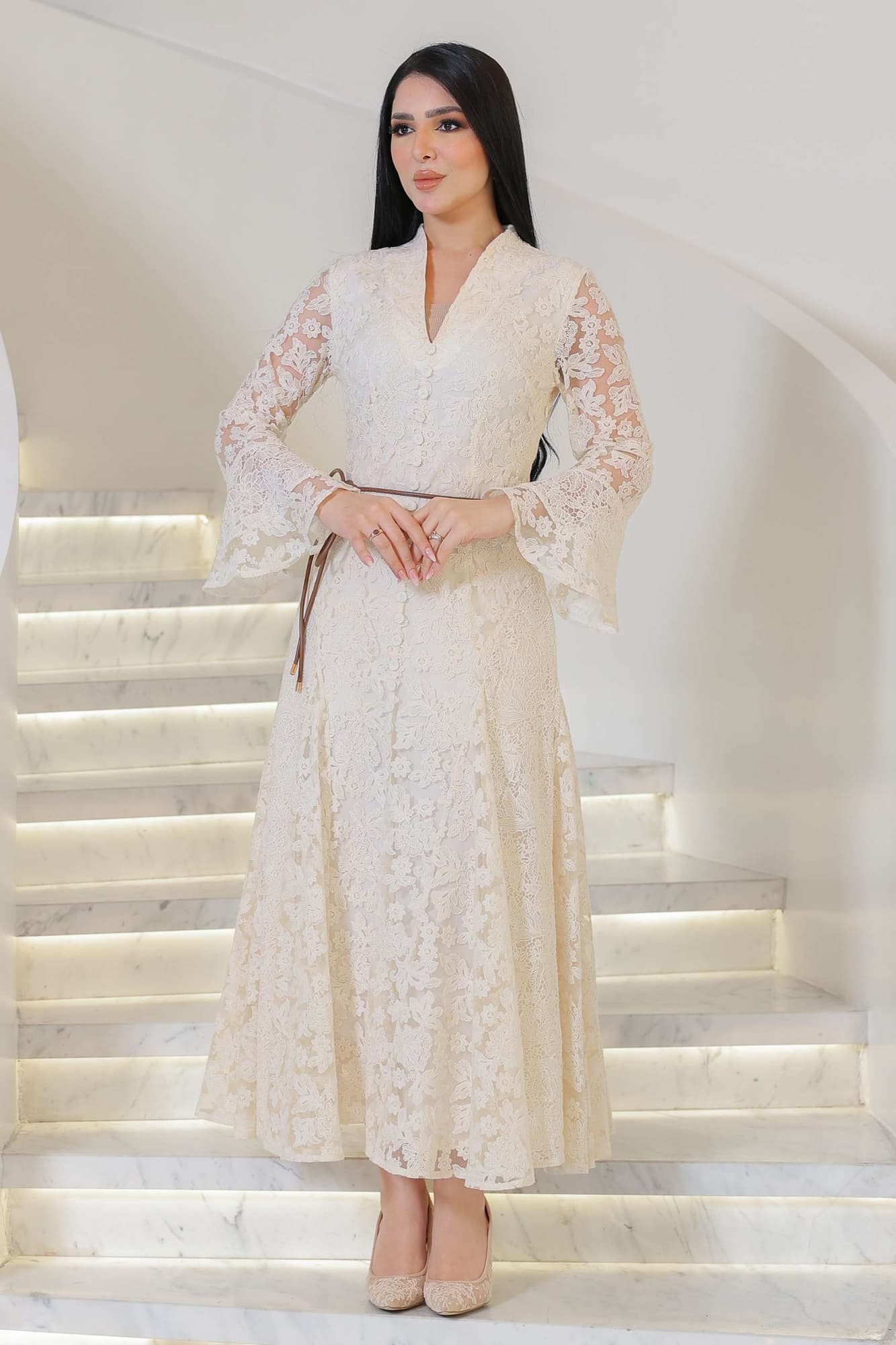 فستان أنثوي راقٍ يجمع بين البساطة والفخامة، مصنوع من دانتيل ناعم بلون أوف وايت يعكس إحساس الرقي