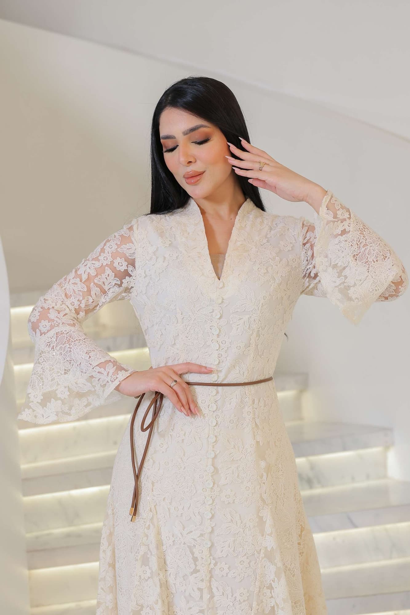 فستان أنثوي راقٍ يجمع بين البساطة والفخامة، مصنوع من دانتيل ناعم بلون أوف وايت يعكس إحساس الرقي
