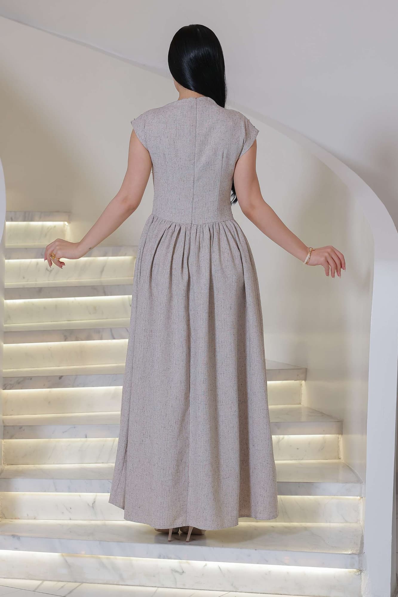 فستان أنيق يجمع بين الرقي الكلاسيكي ولمسة عصرية ناعمة، يتميز بلونه الهادئ ونقوشه اللامعة الرقيقة