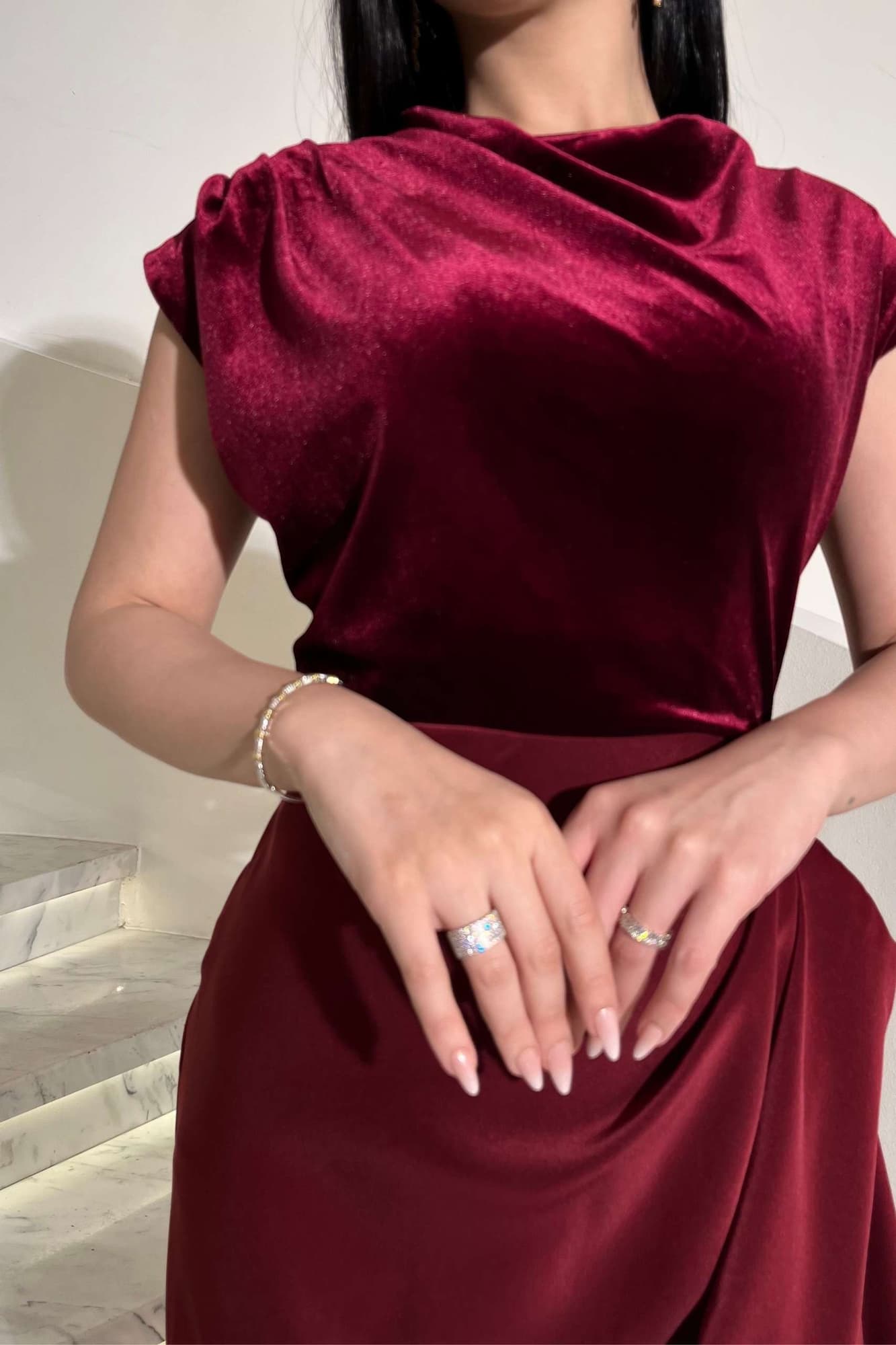 فستان يجمع بين نعومة المخمل في الجزء العلوي وانسيابية قماش الساتان في الاسفل ليخلق تباينًا غنيًا بالفخامة والأنوثة عودي