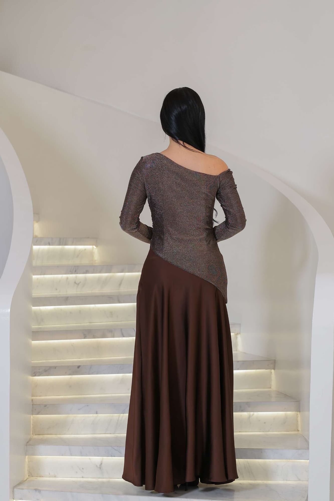 فستان أنيق بنفحة دافئة من الفخامة يجمع بين لمعان راقٍ ونعومة انسيابية