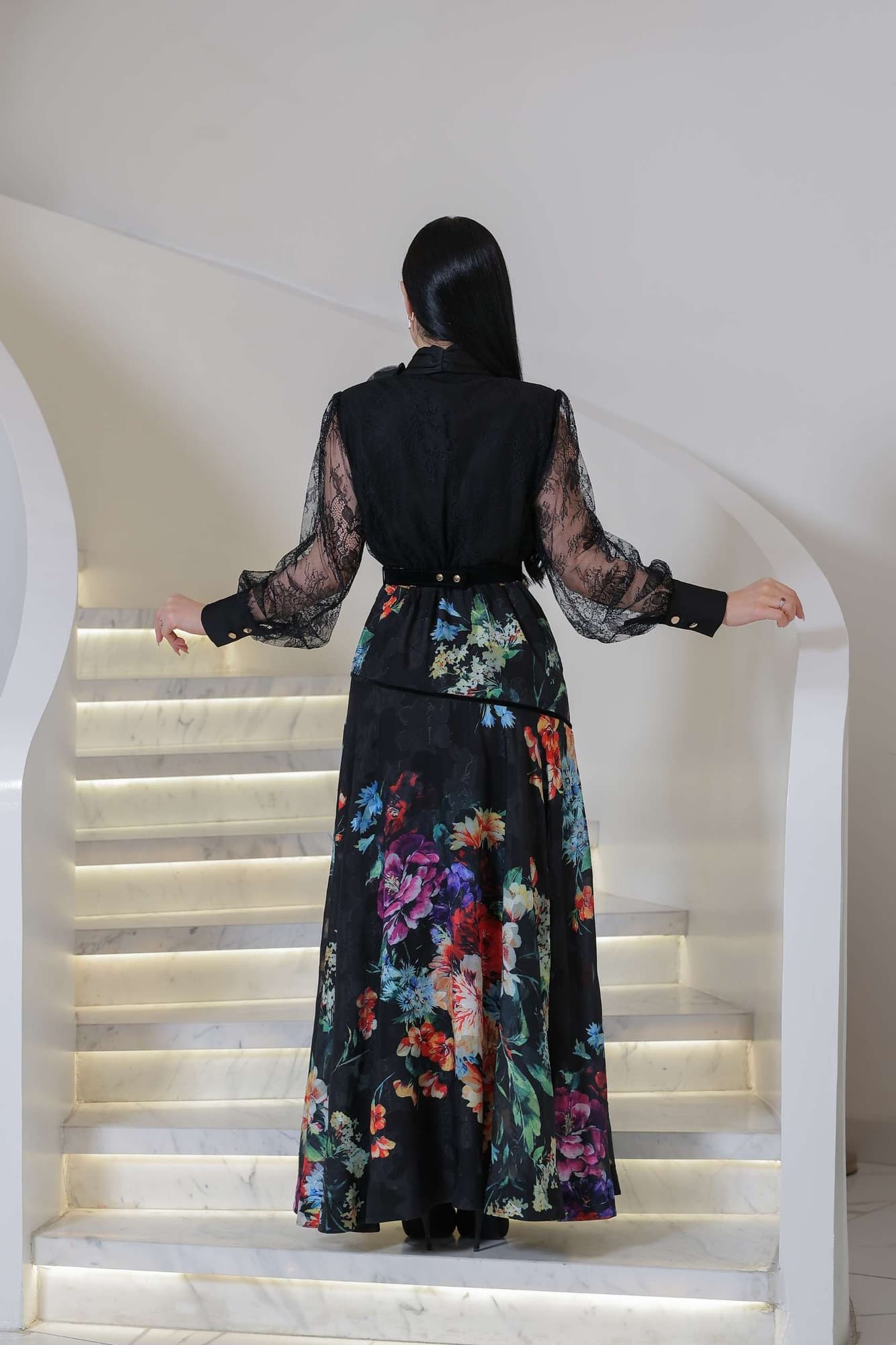 فستان أنيق يجمع بين الرقي والأنوثة، بتصميم أسود راقٍ مزدان بنقشات زهرية ملونة