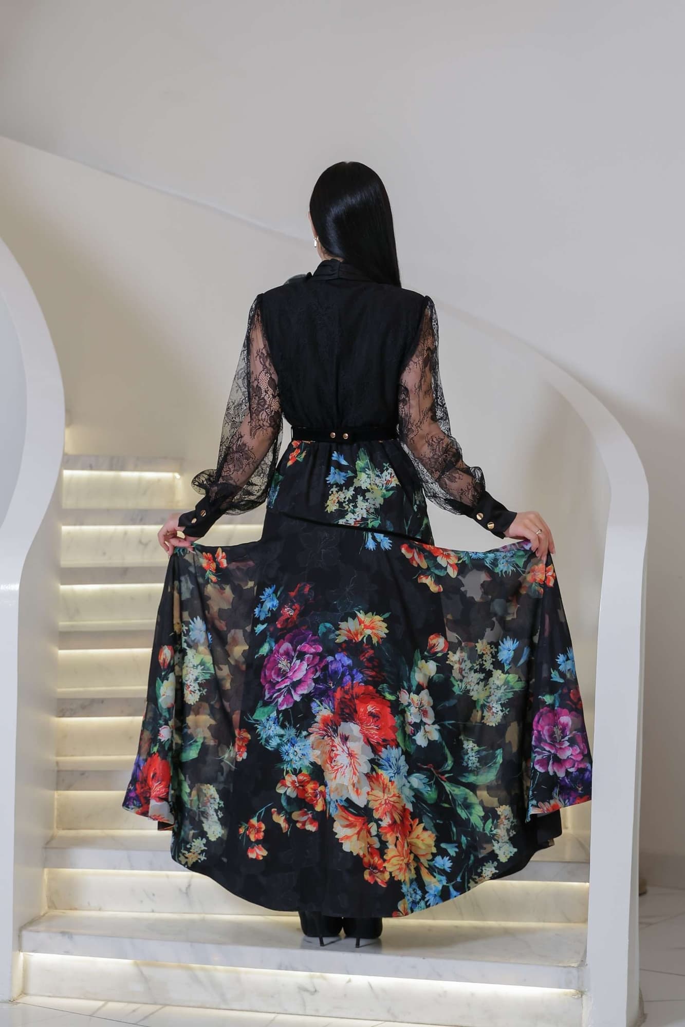 فستان أنيق يجمع بين الرقي والأنوثة، بتصميم أسود راقٍ مزدان بنقشات زهرية ملونة