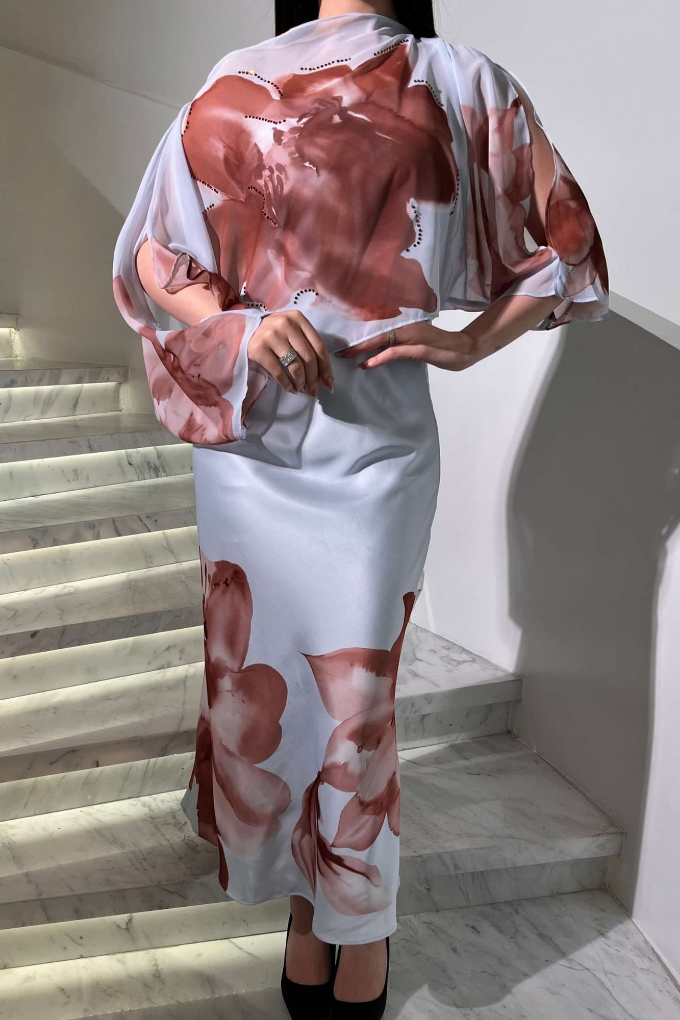 فستان أنثوي راقٍ يجمع بين الرومانسية والفن بتدرجات ناعمة مع طبعات وردية