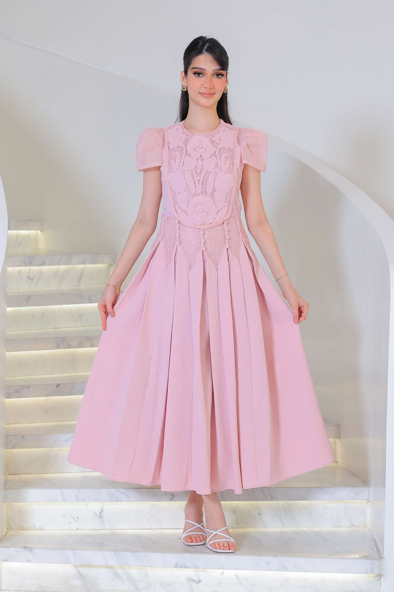 فستان أنيق بطابع ناعم وأنثوي يتميز بتفاصيل دانتيل وزخارف بارزة